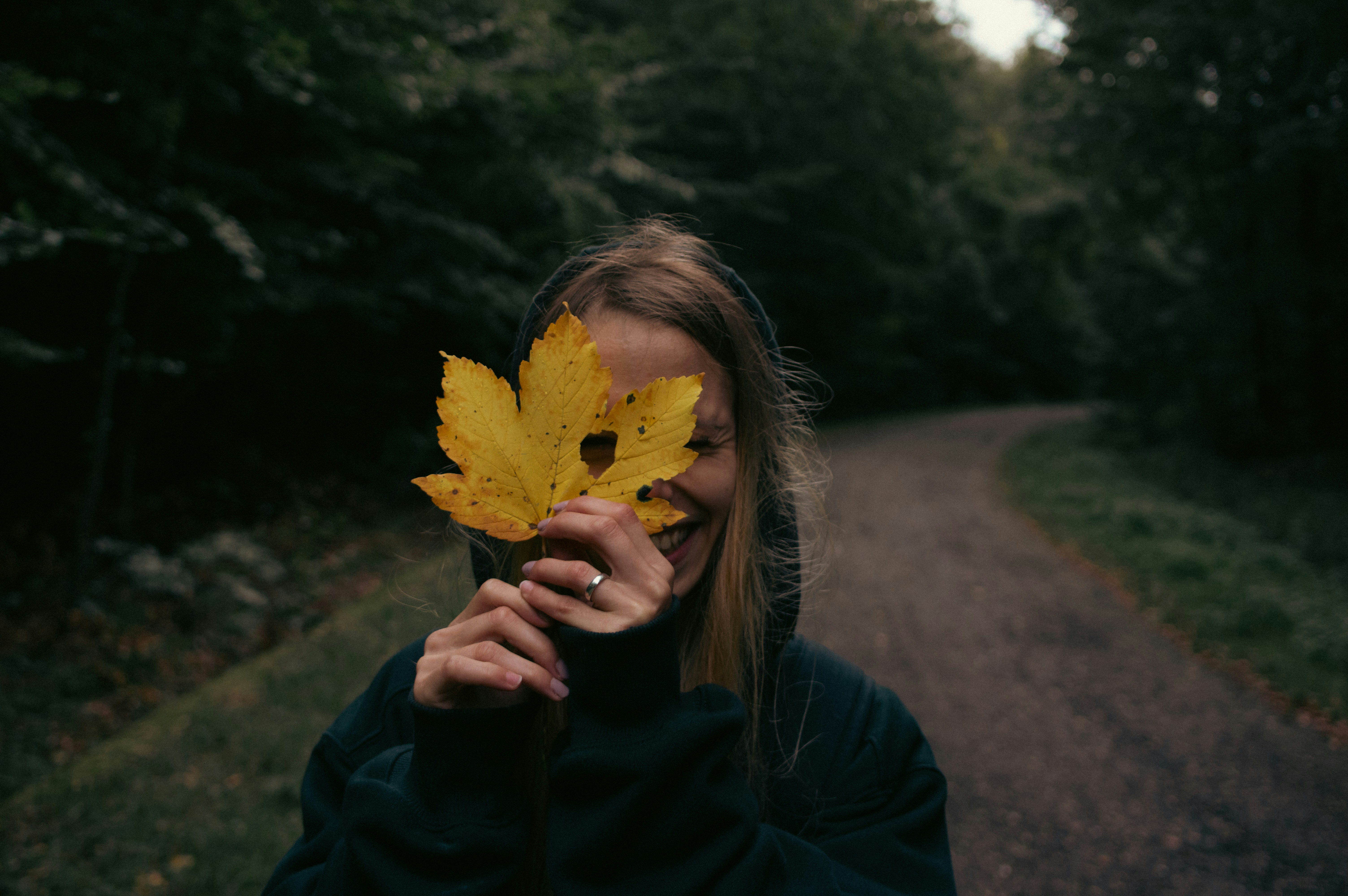 A woman holding a leaf in front of her face