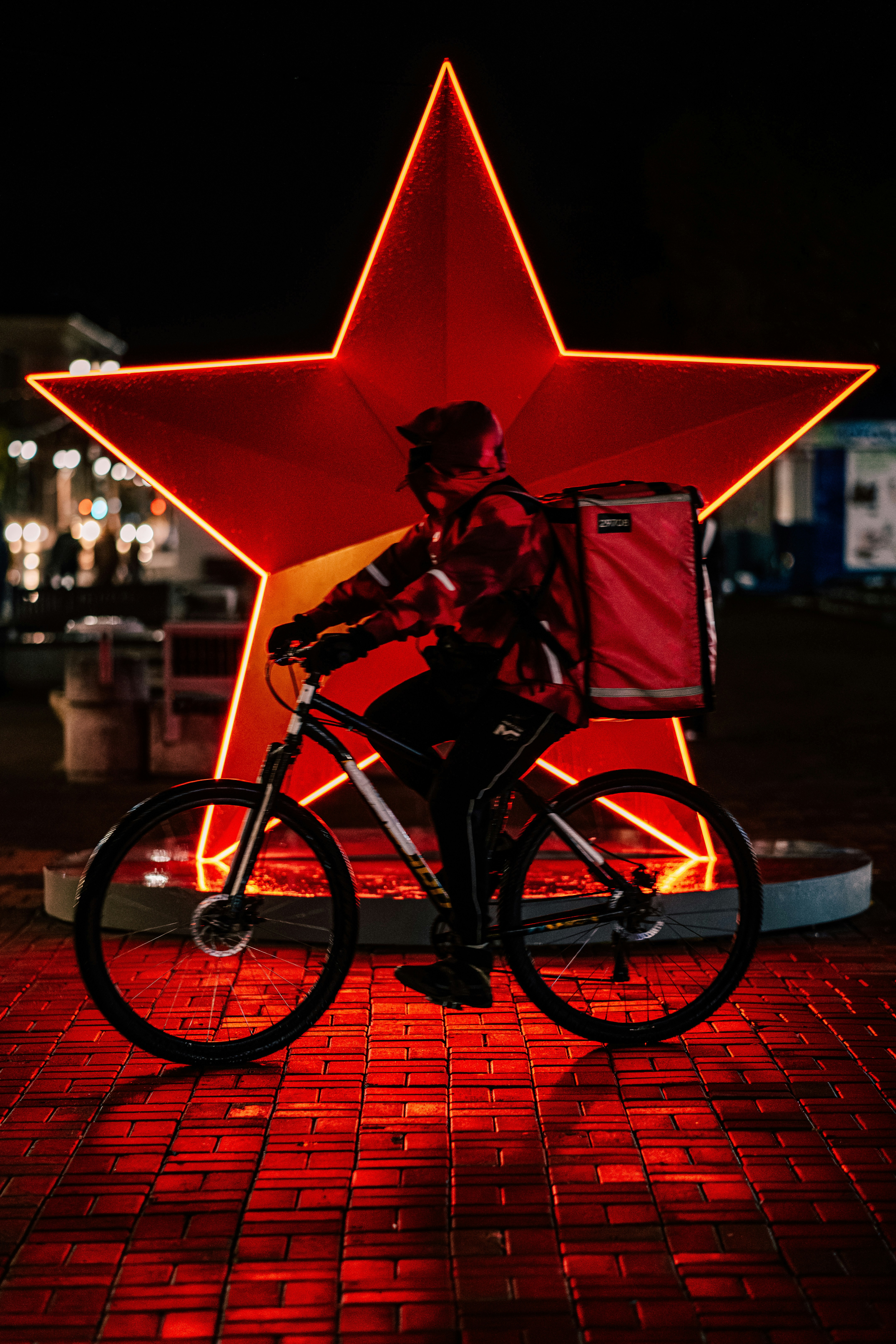 A man riding a bike next to a red star