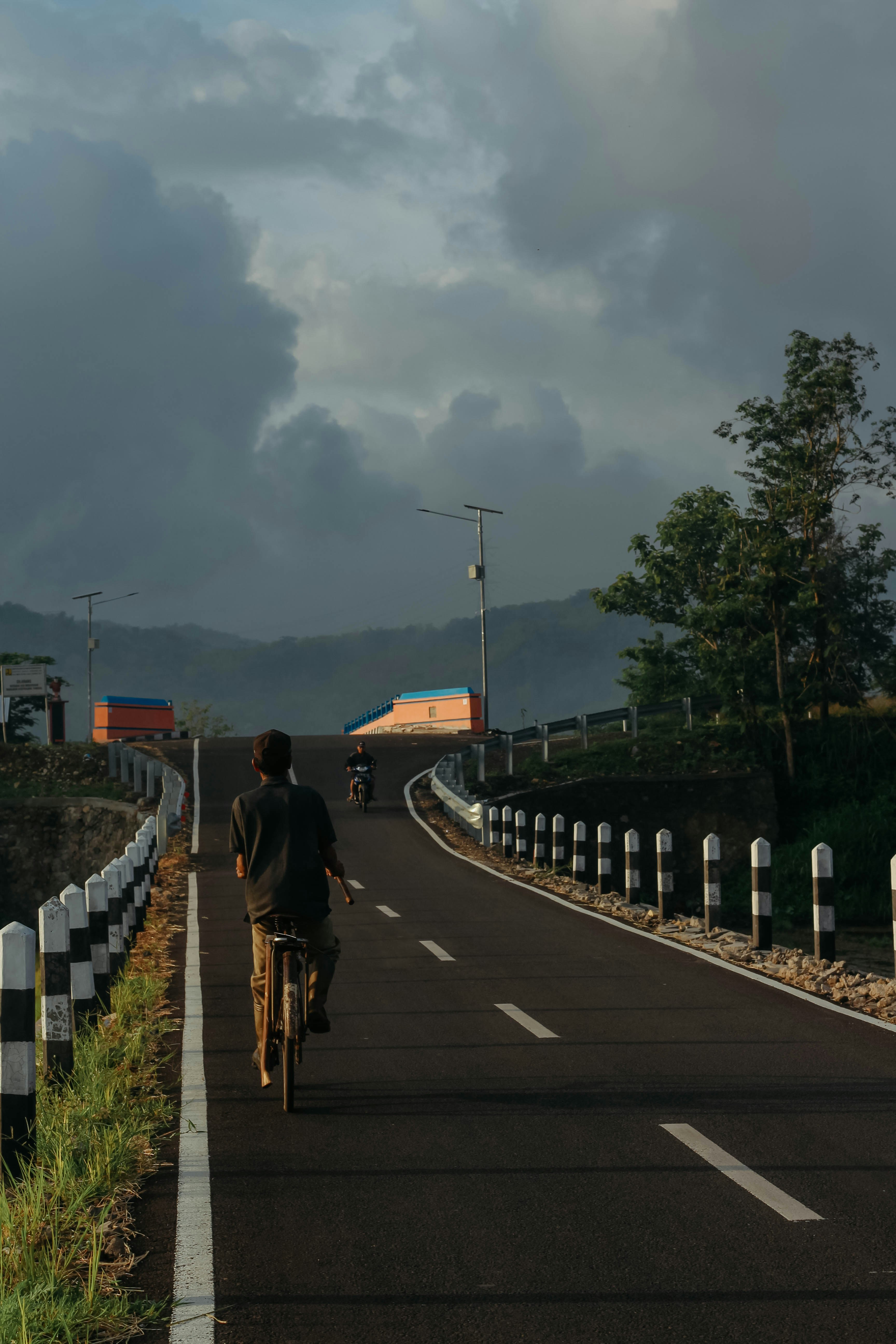 曇り空の下、自転車で道を走る男性
