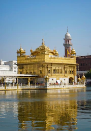 A large golden building sitting next to a body of water