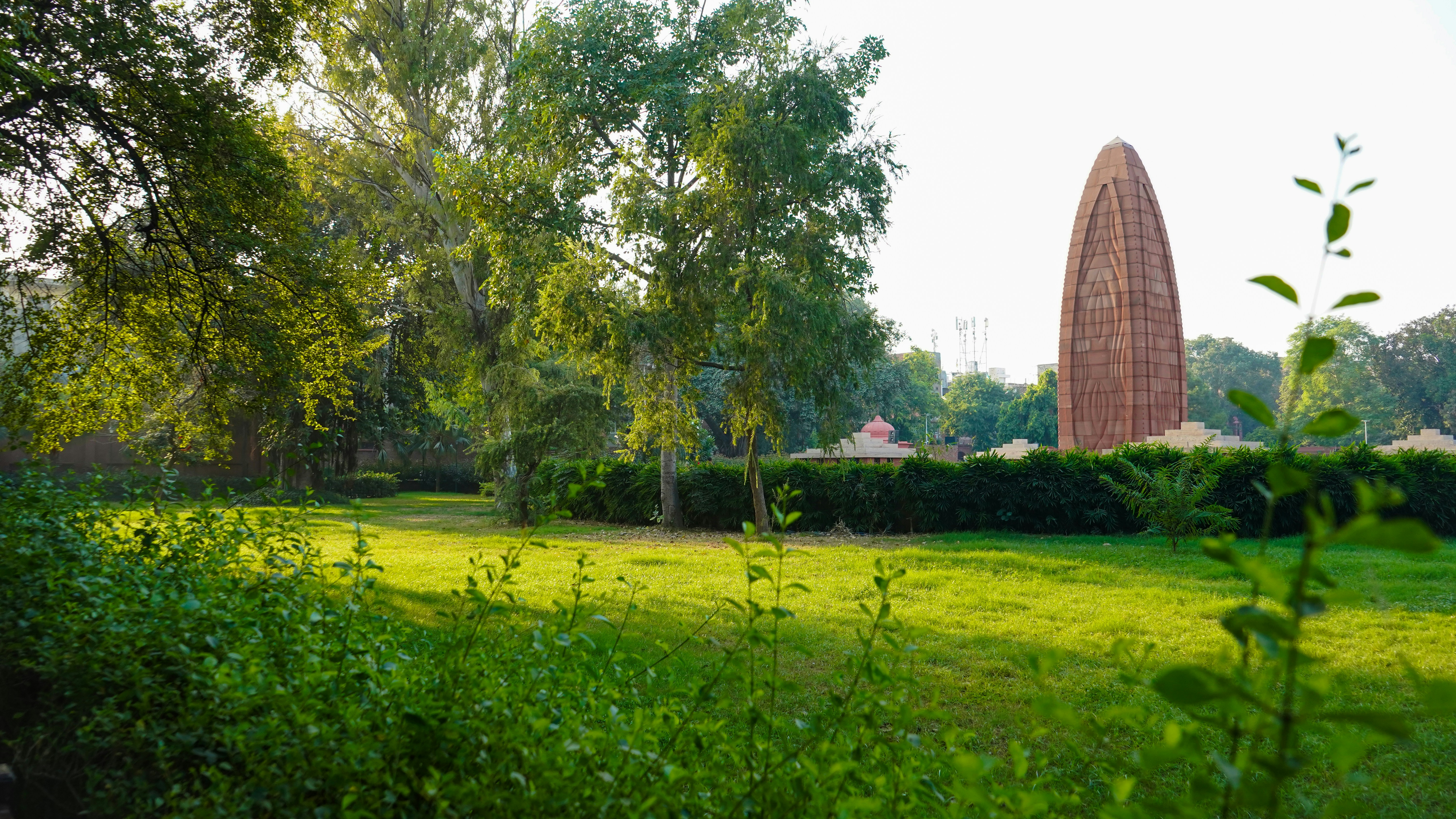 A grassy field with a tall obelisk in the background