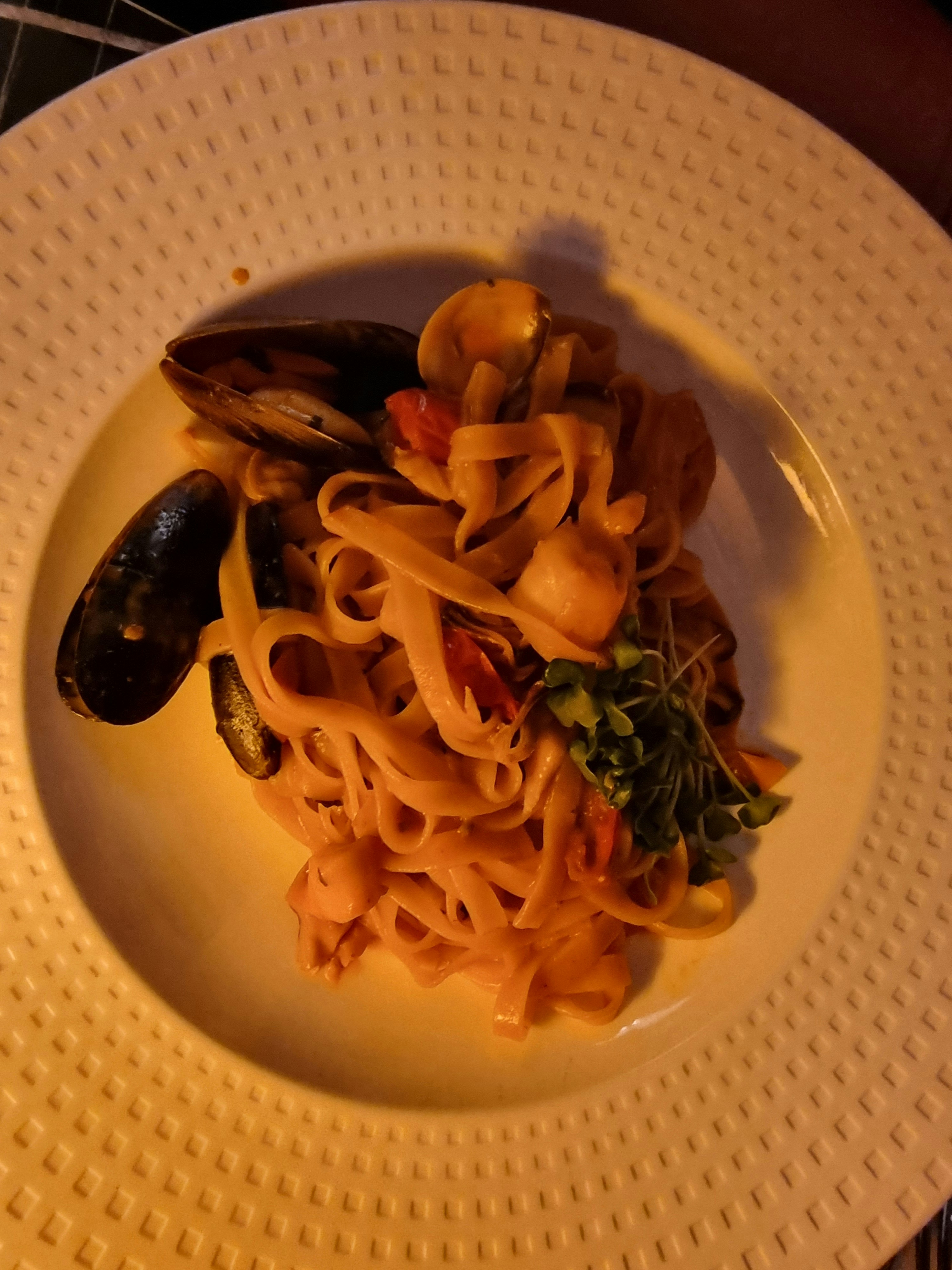 Tagliatelle pasta with black truffle on dark ceramic plate