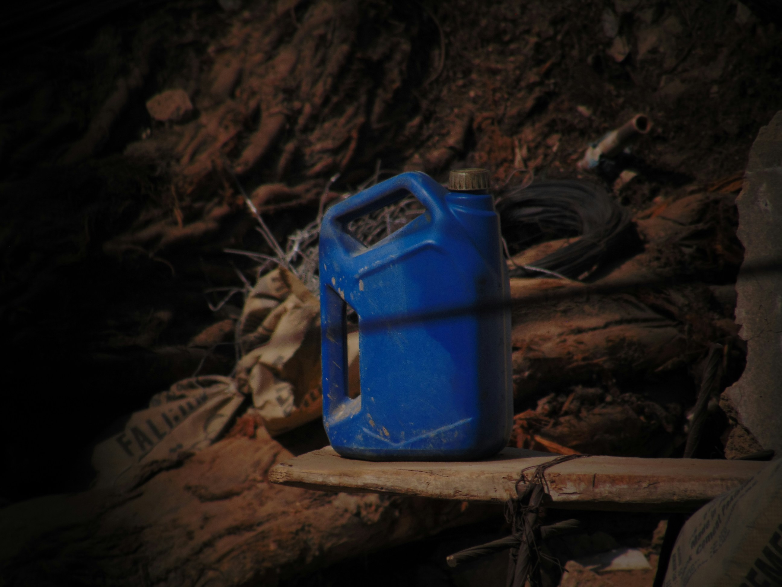 A blue container sitting on top of a pile of dirt