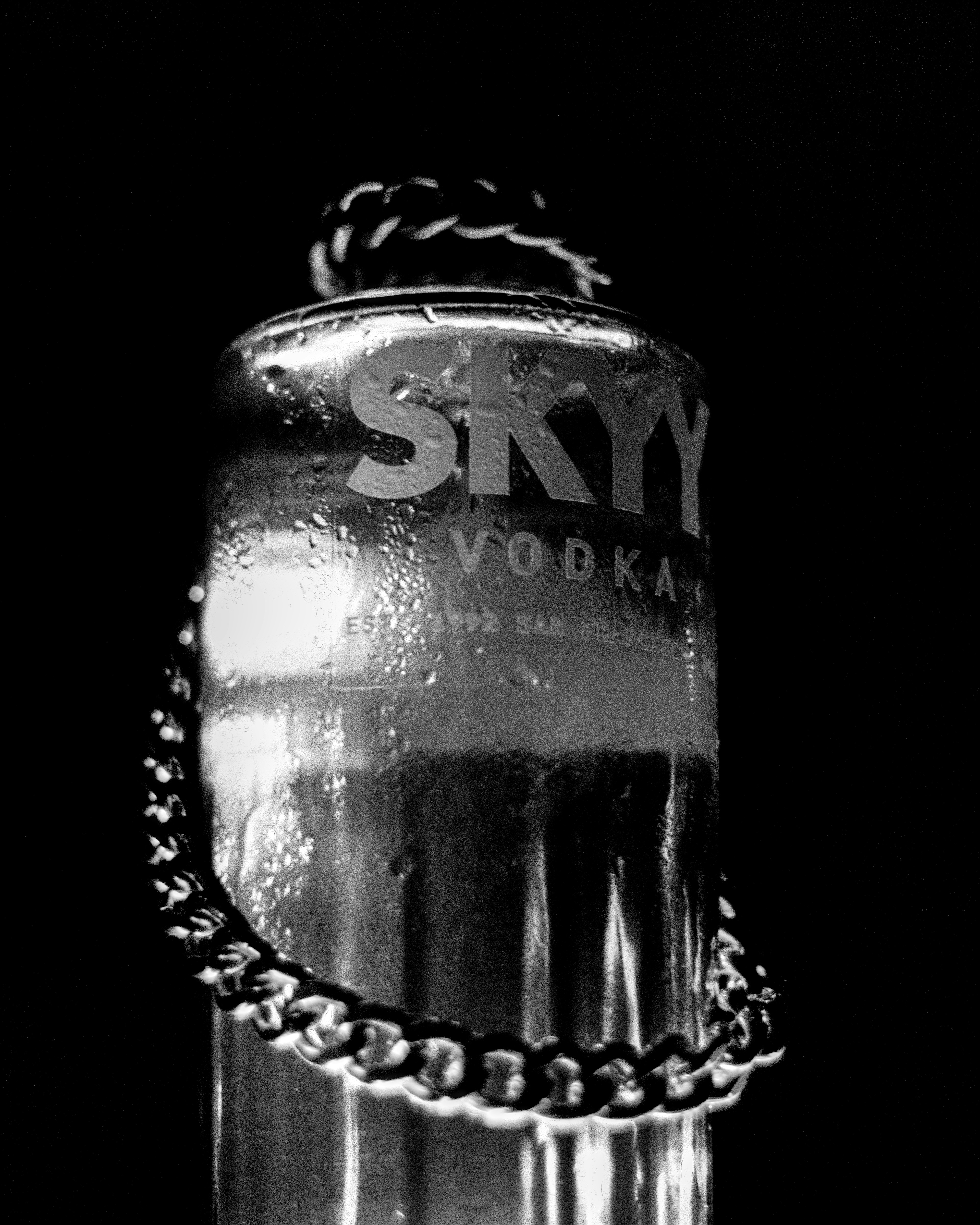 A black and white photo of a bottle of vodka