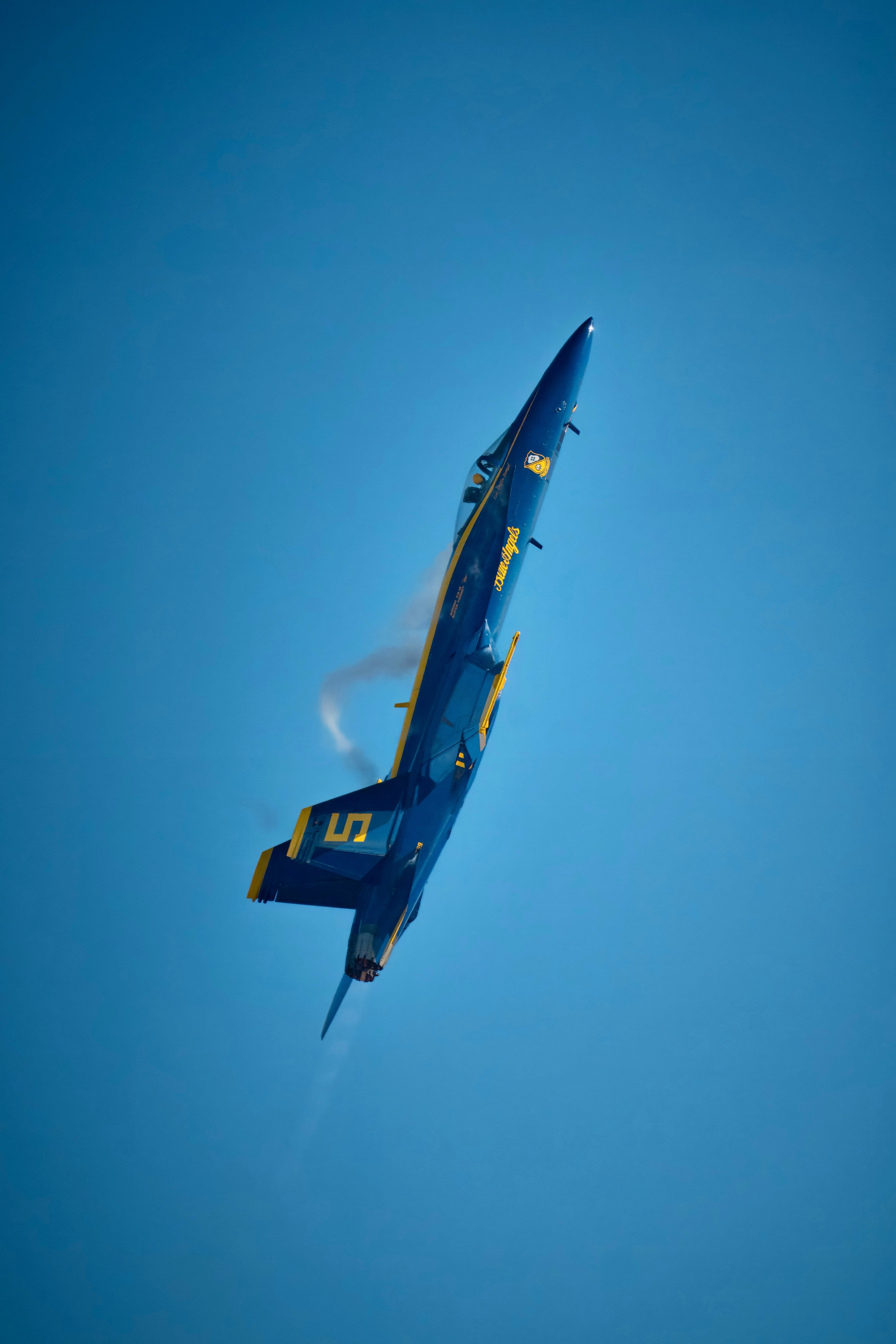 A fighter jet flying through a blue sky