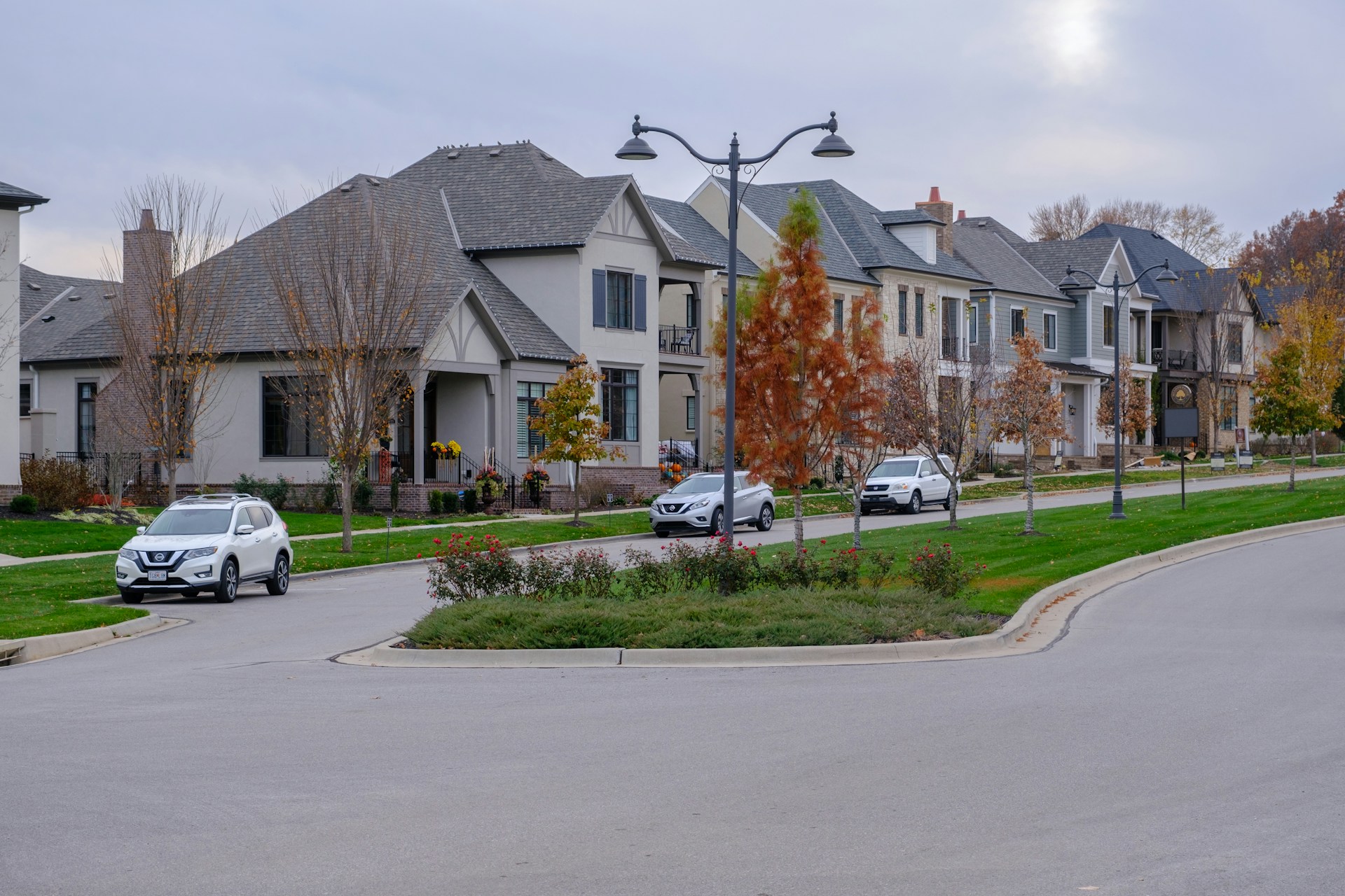 A row of houses with cars parked on the street