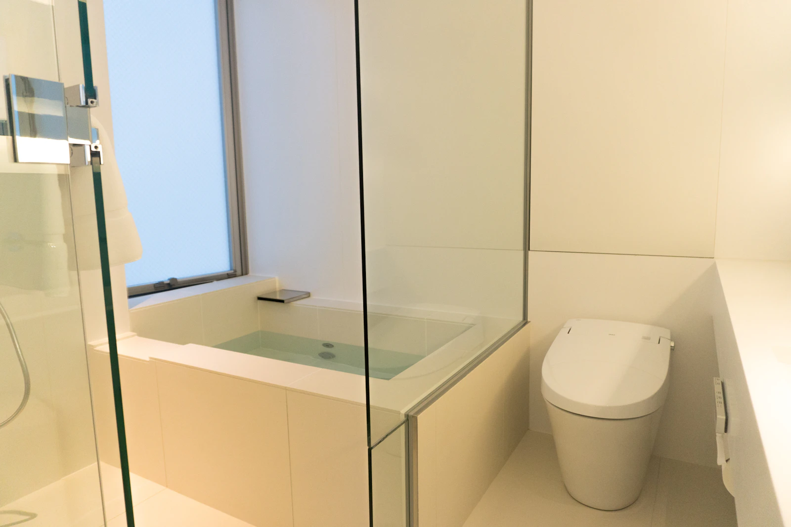 A small modern bathroom with a glass shower and toilet