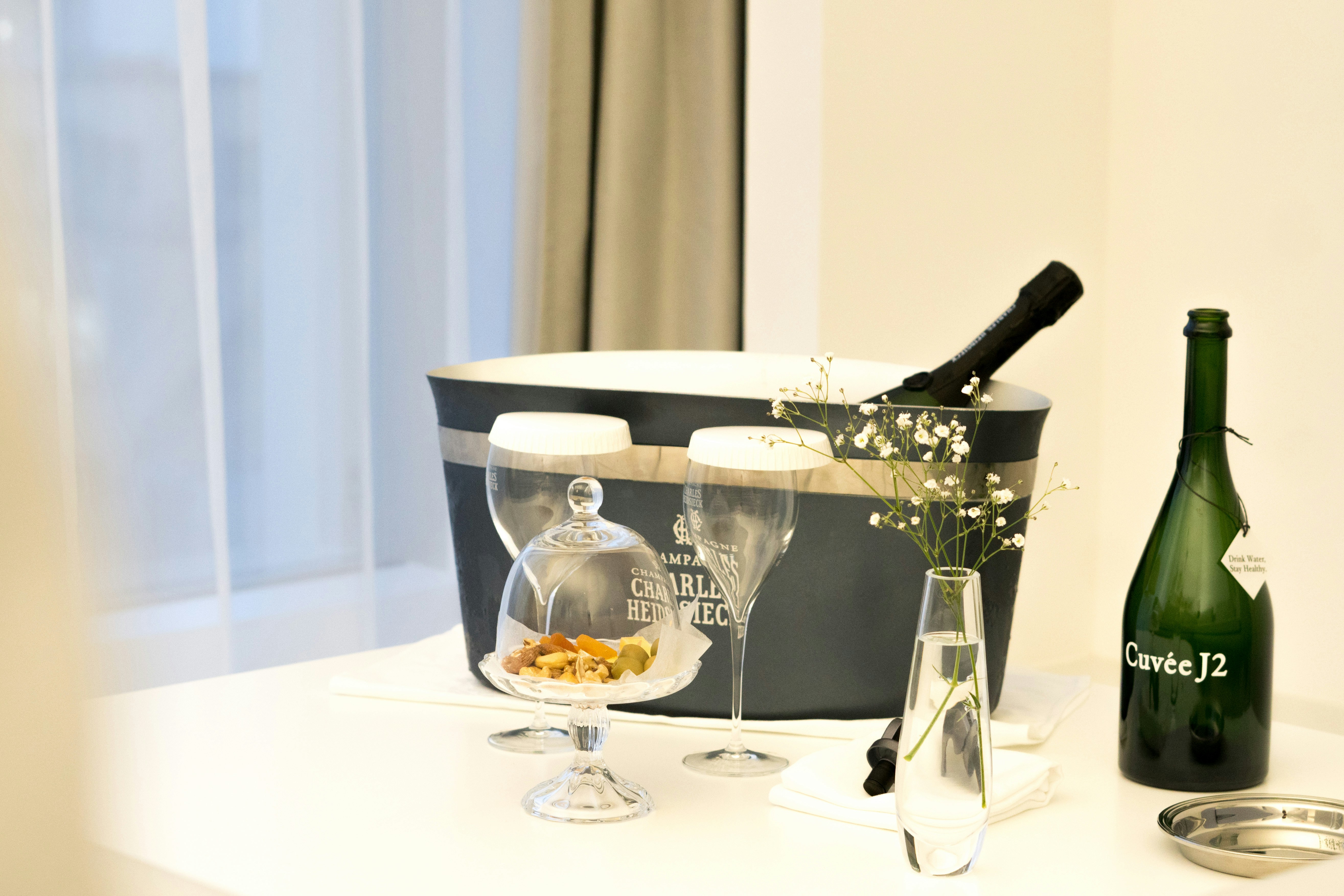 A table with a bottle of wine and a basket of food