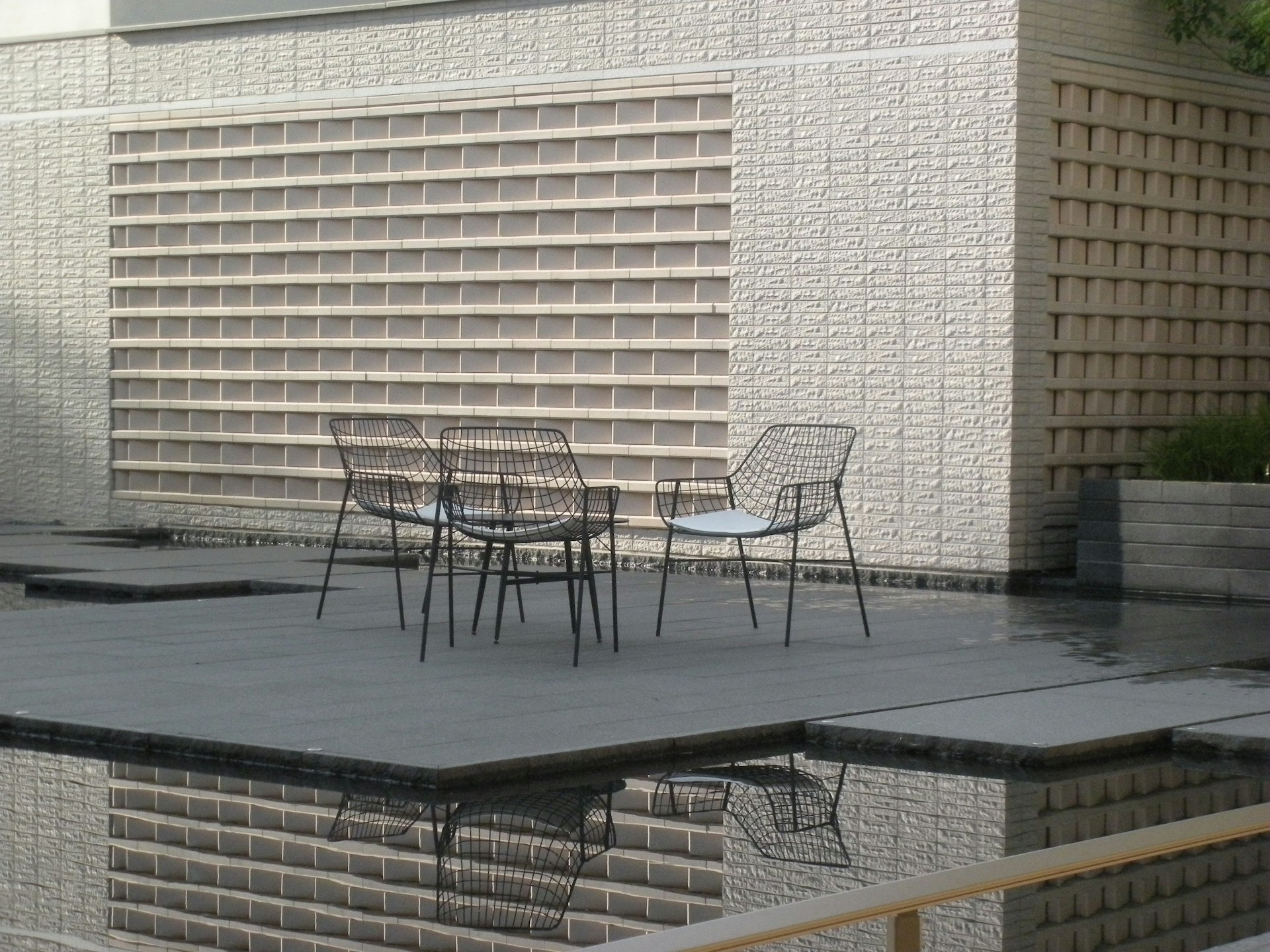 A table and chairs sitting on a patio next to a pool