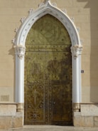 A large gold door with a white arch