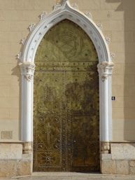 A large gold door with a white arch