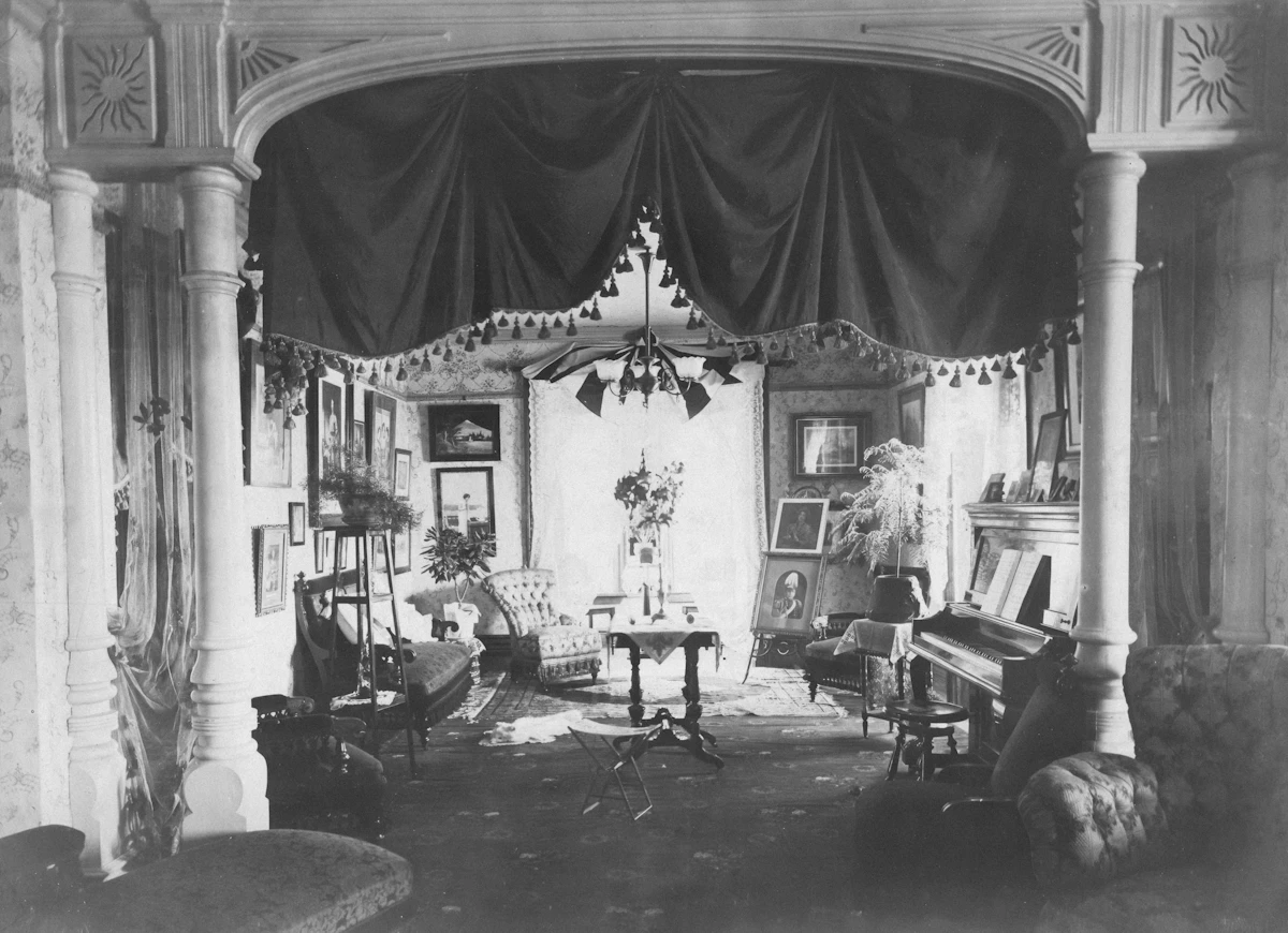 Ornate victorian parlor with piano and artwork