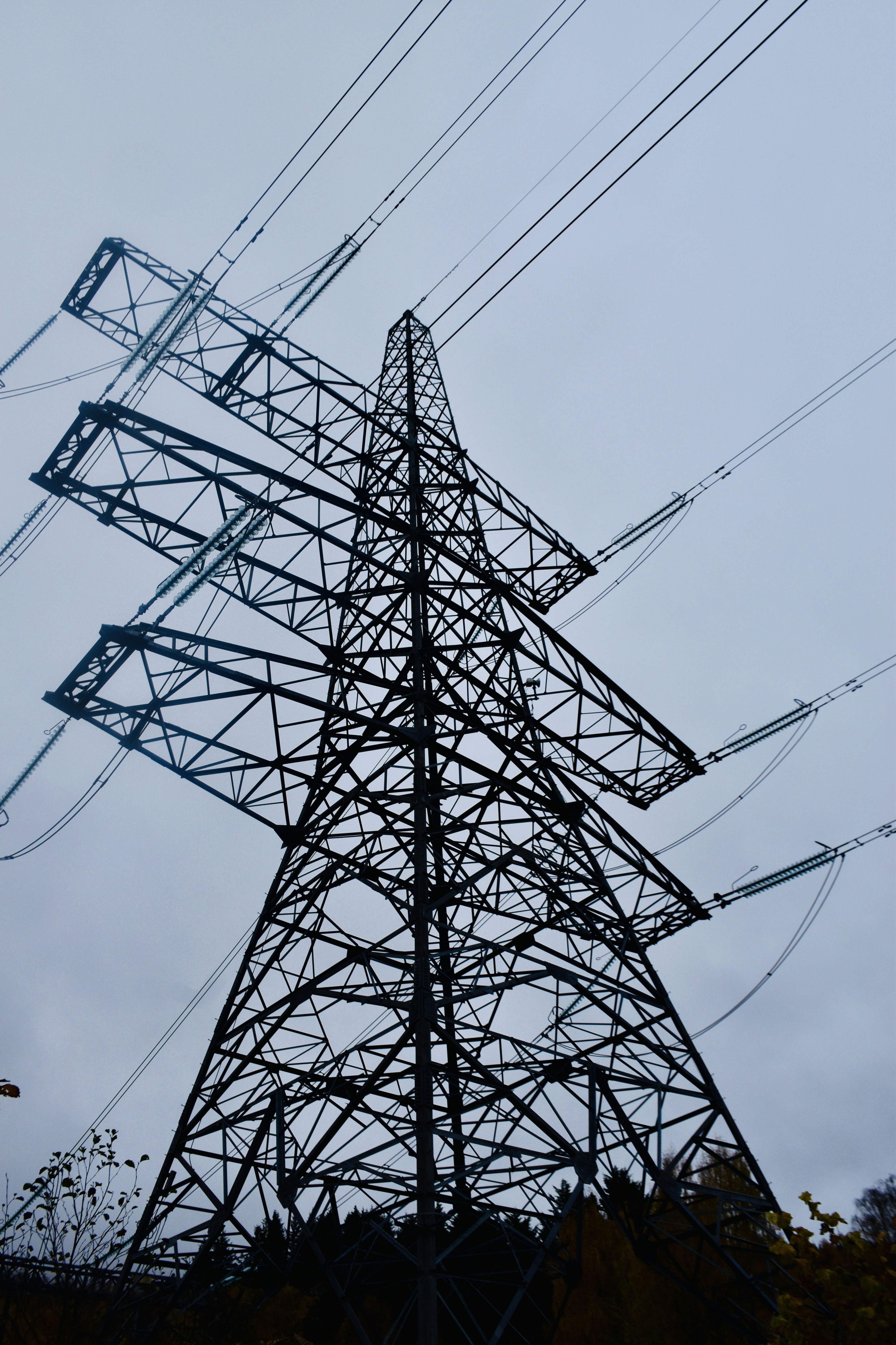 A tall metal tower with lots of wires above it