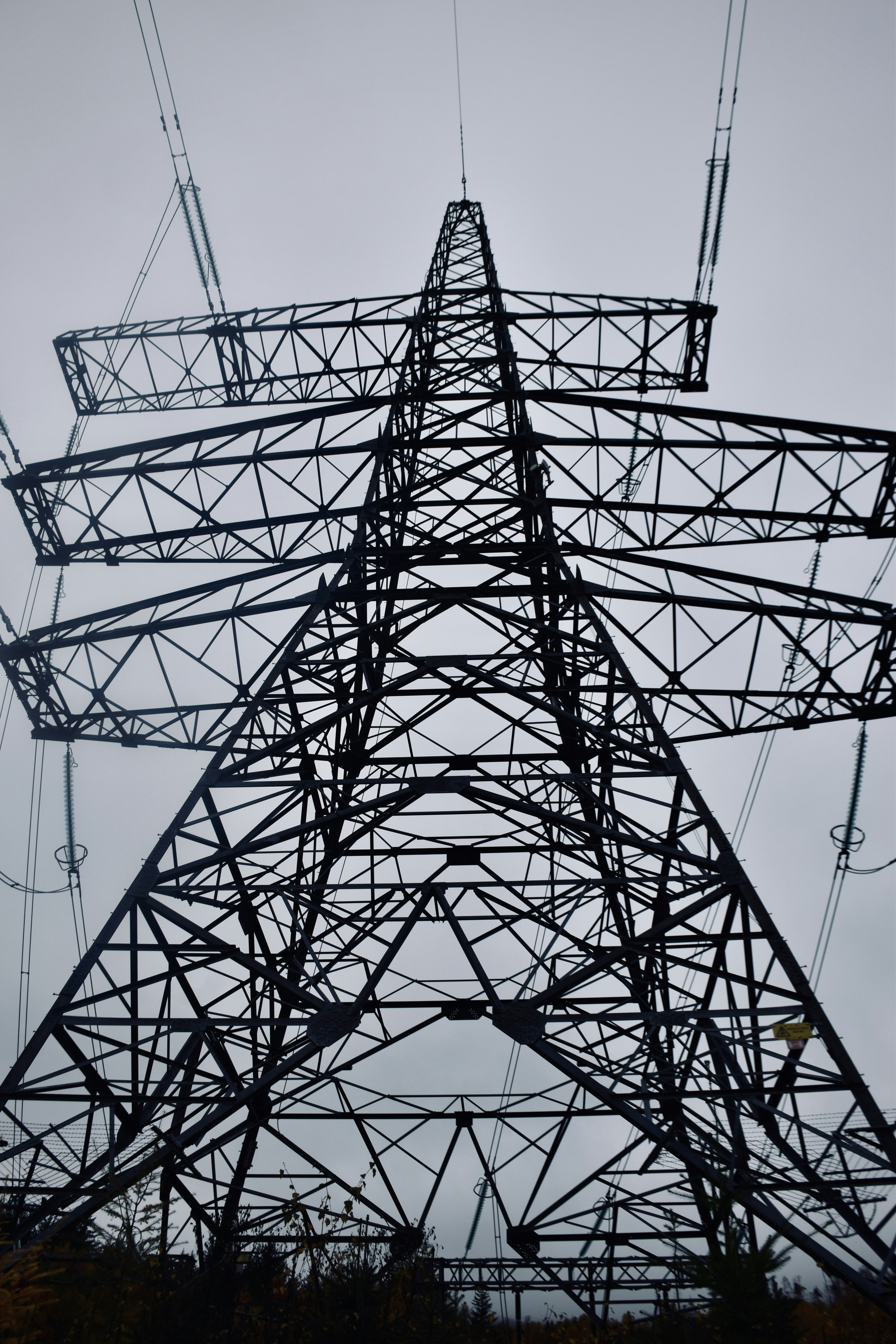 A tall metal tower with lots of wires above it