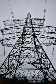 A tall metal tower with lots of wires above it