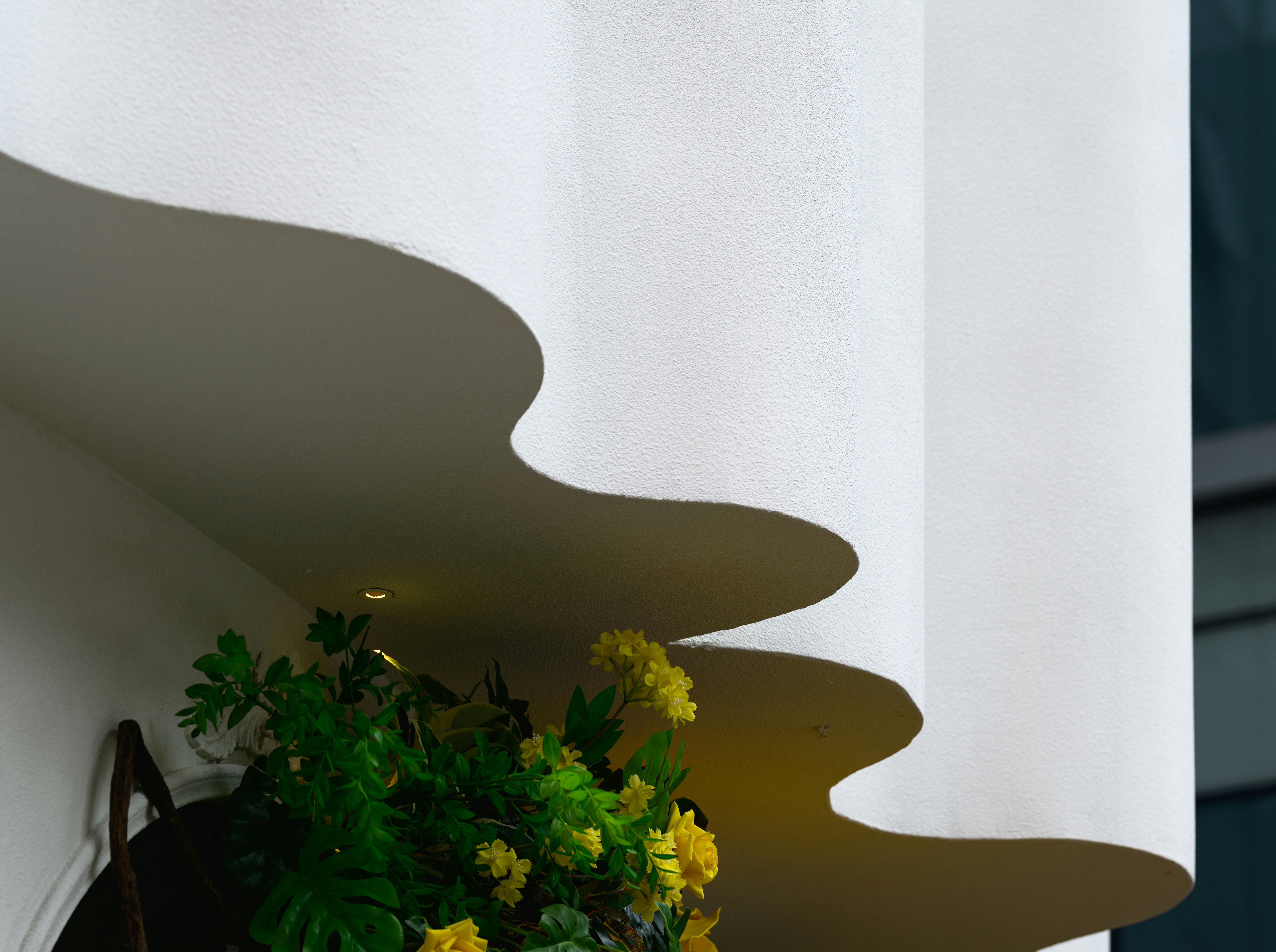 A vase with yellow flowers sitting on a ledge