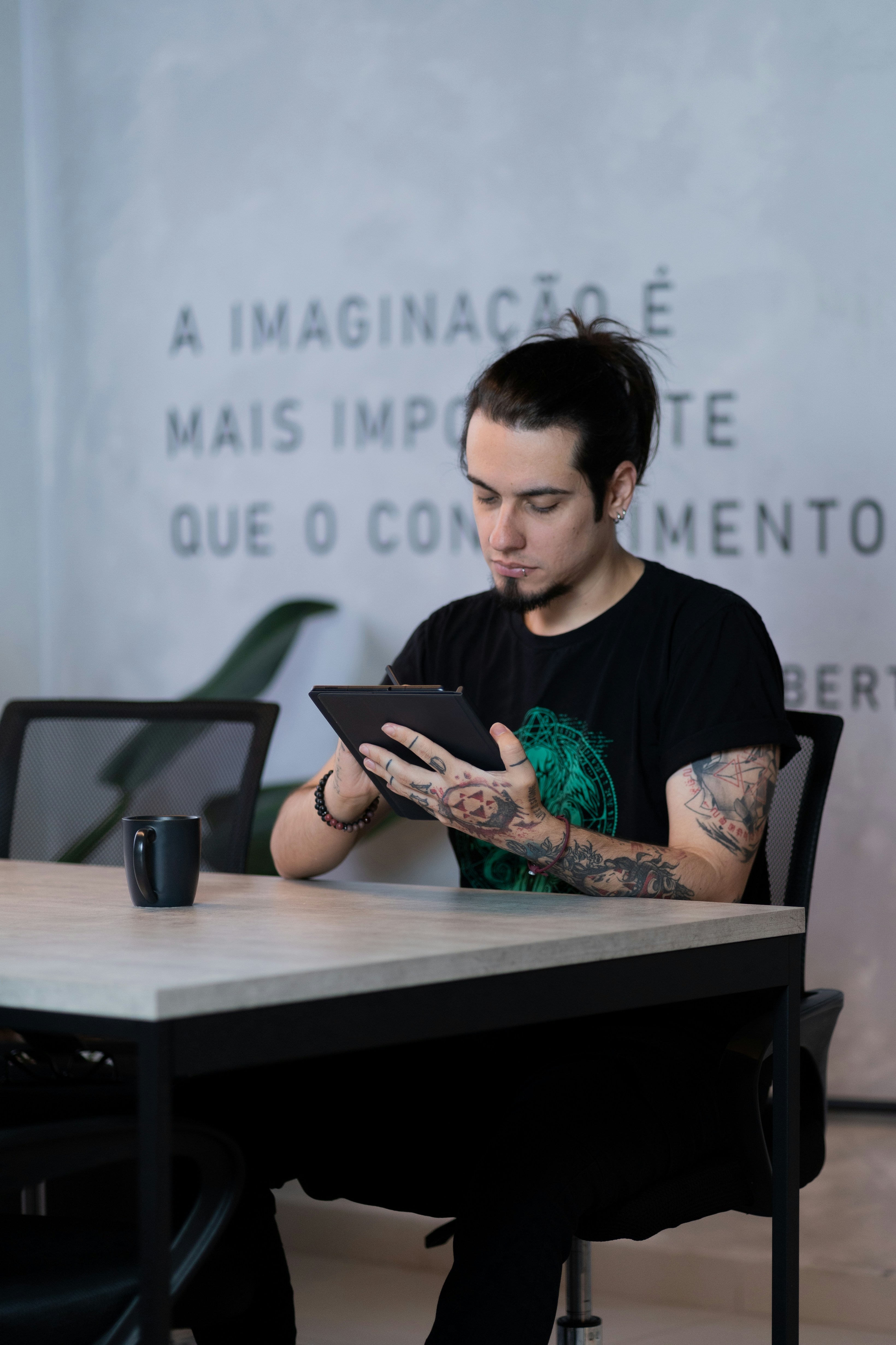 A man sitting at a table using a tablet
