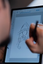 A person drawing on a tablet with a pen
