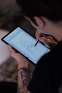 A person with a pen and a tablet
