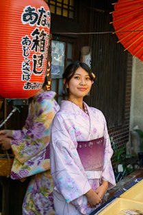 A woman in a kimono standing in front of a store