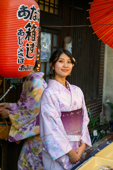 A woman in a kimono standing in front of a store