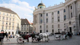 A horse drawn carriage in front of a large building