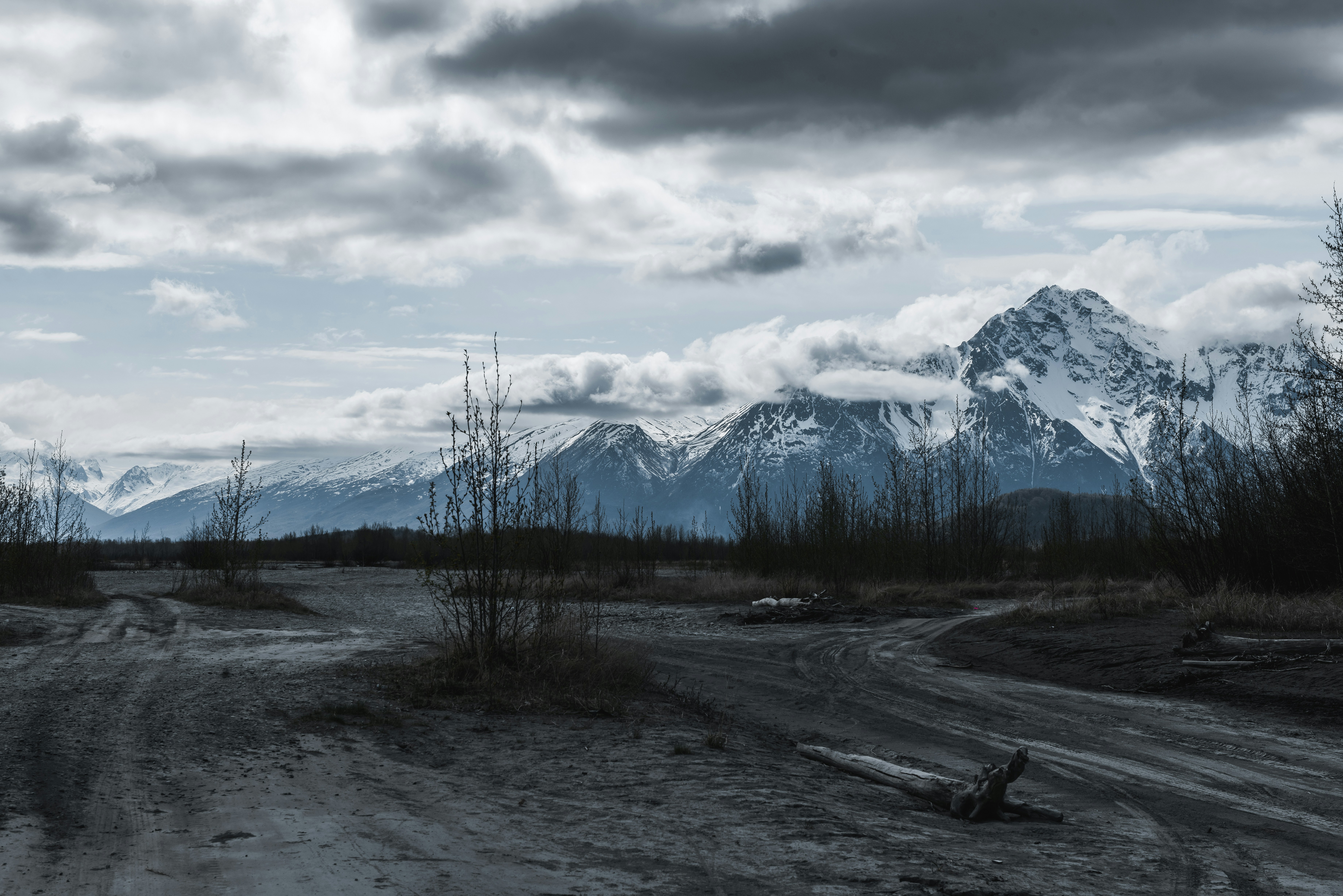 A dirt road in front of a mountain range