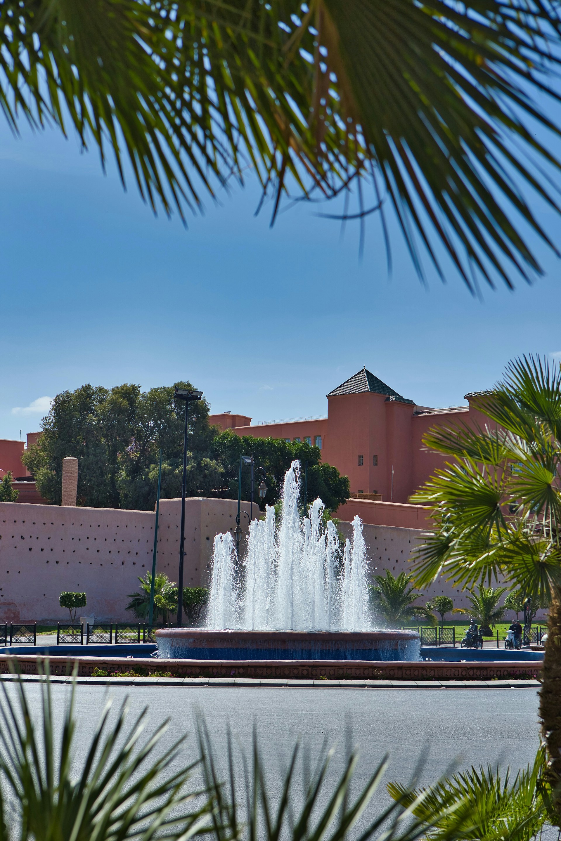 A fountain in front of a building with a clock on it