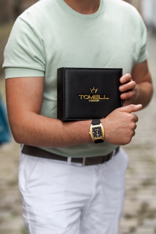 A man in a green shirt holding a black book
