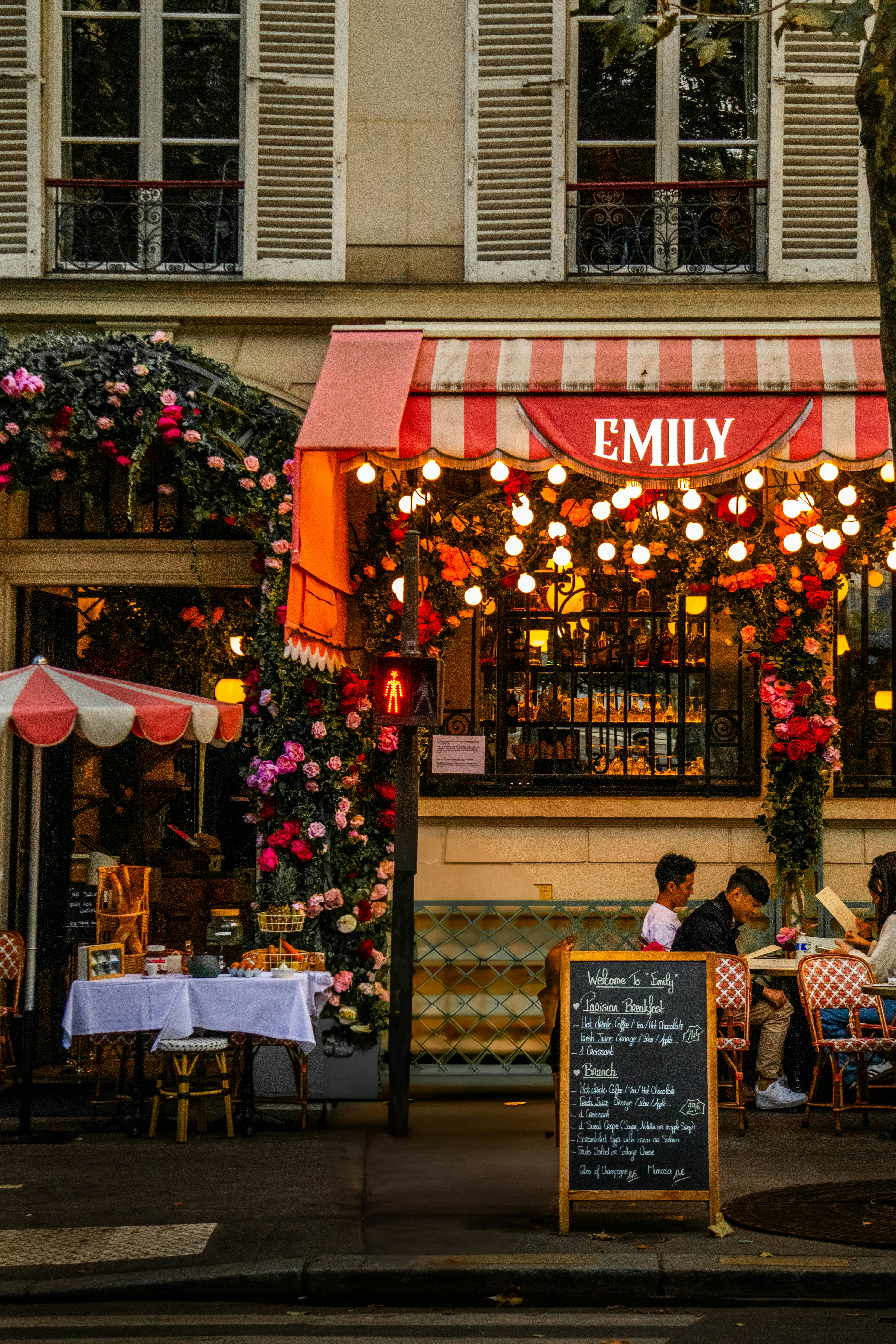 A couple of people sitting at a table outside of a restaurant