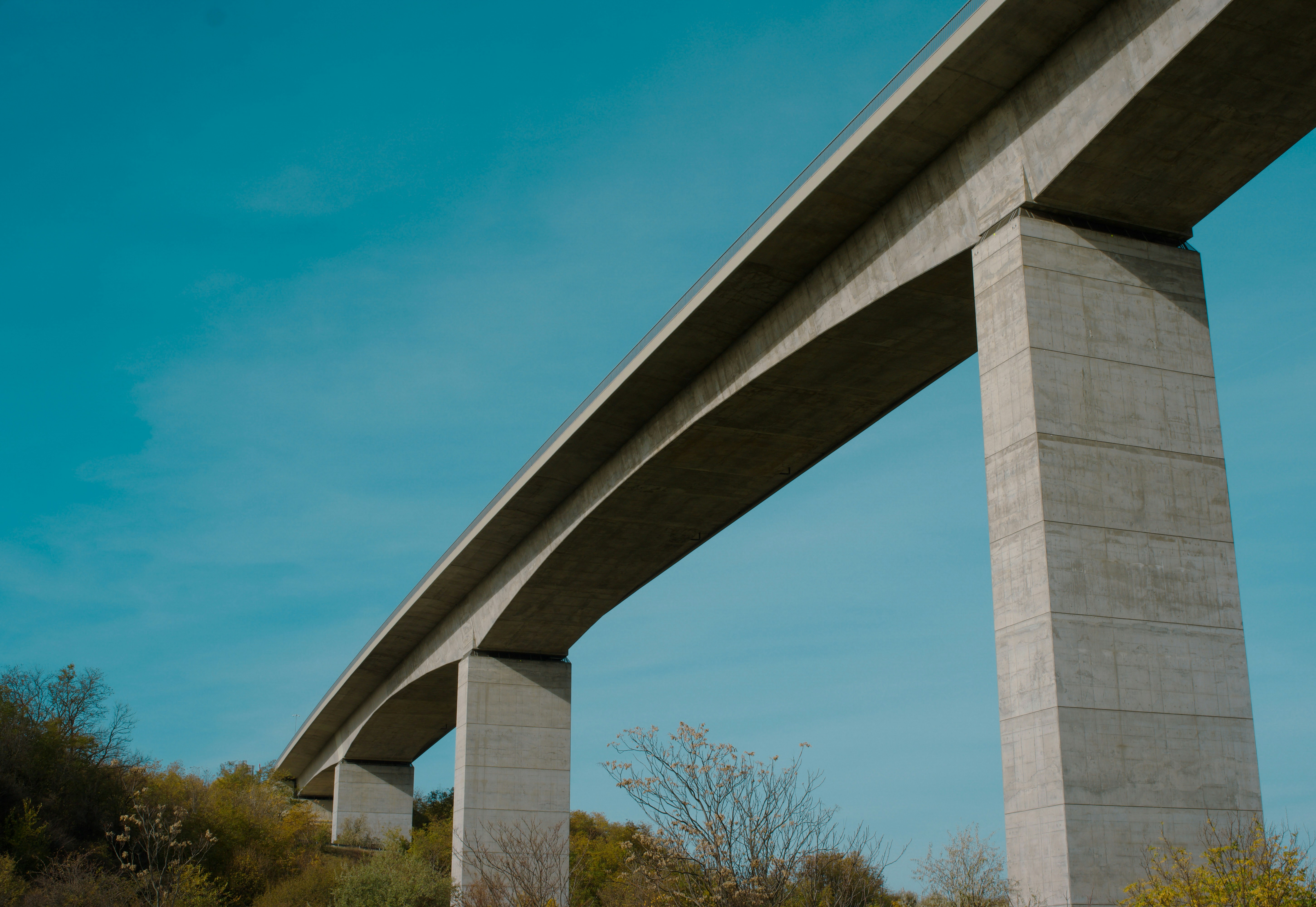 A large bridge spanning over a lush green hillside