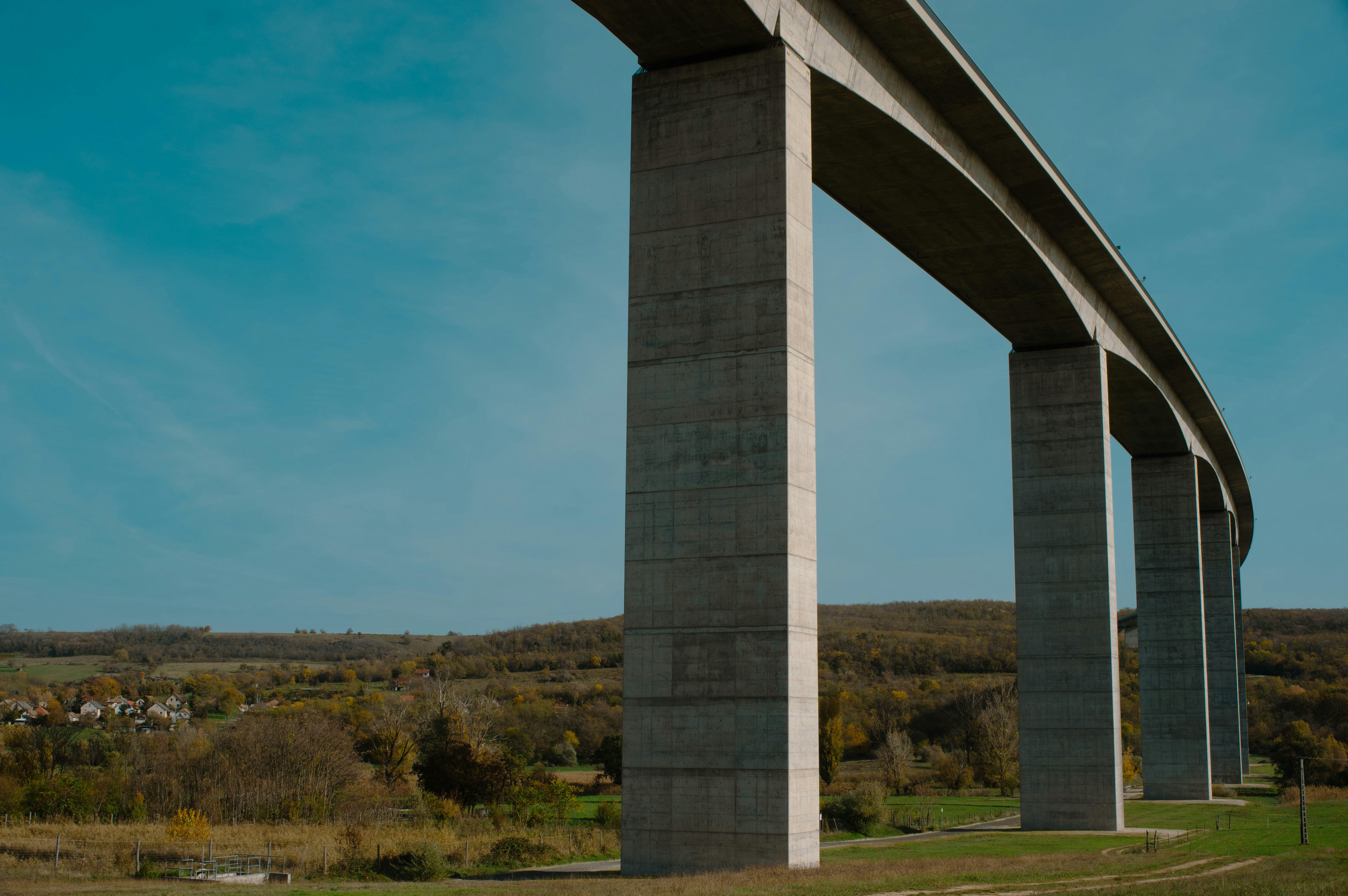 A very tall bridge over a lush green field