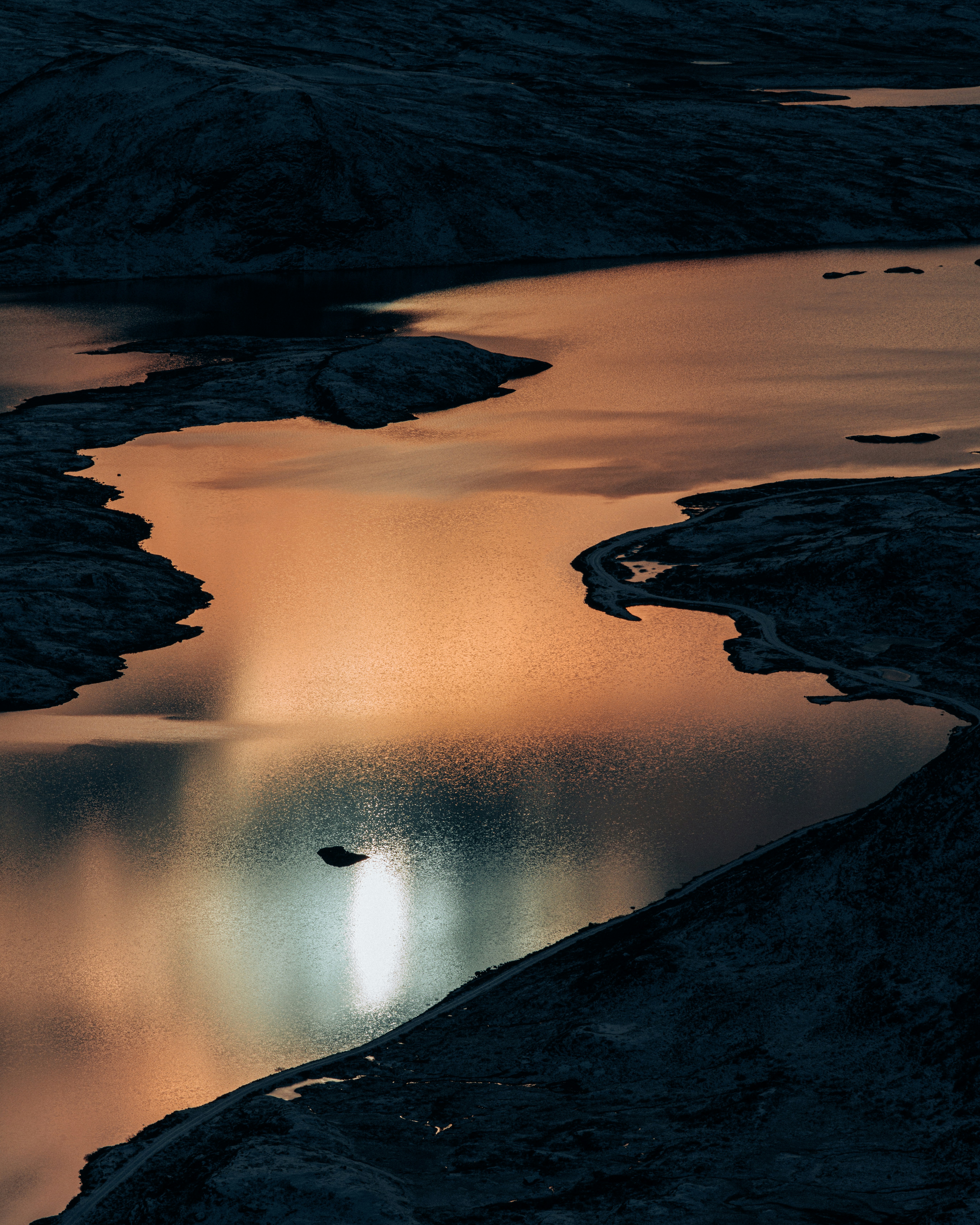 Ein Gewässer, das nachts von Bergen umgeben ist