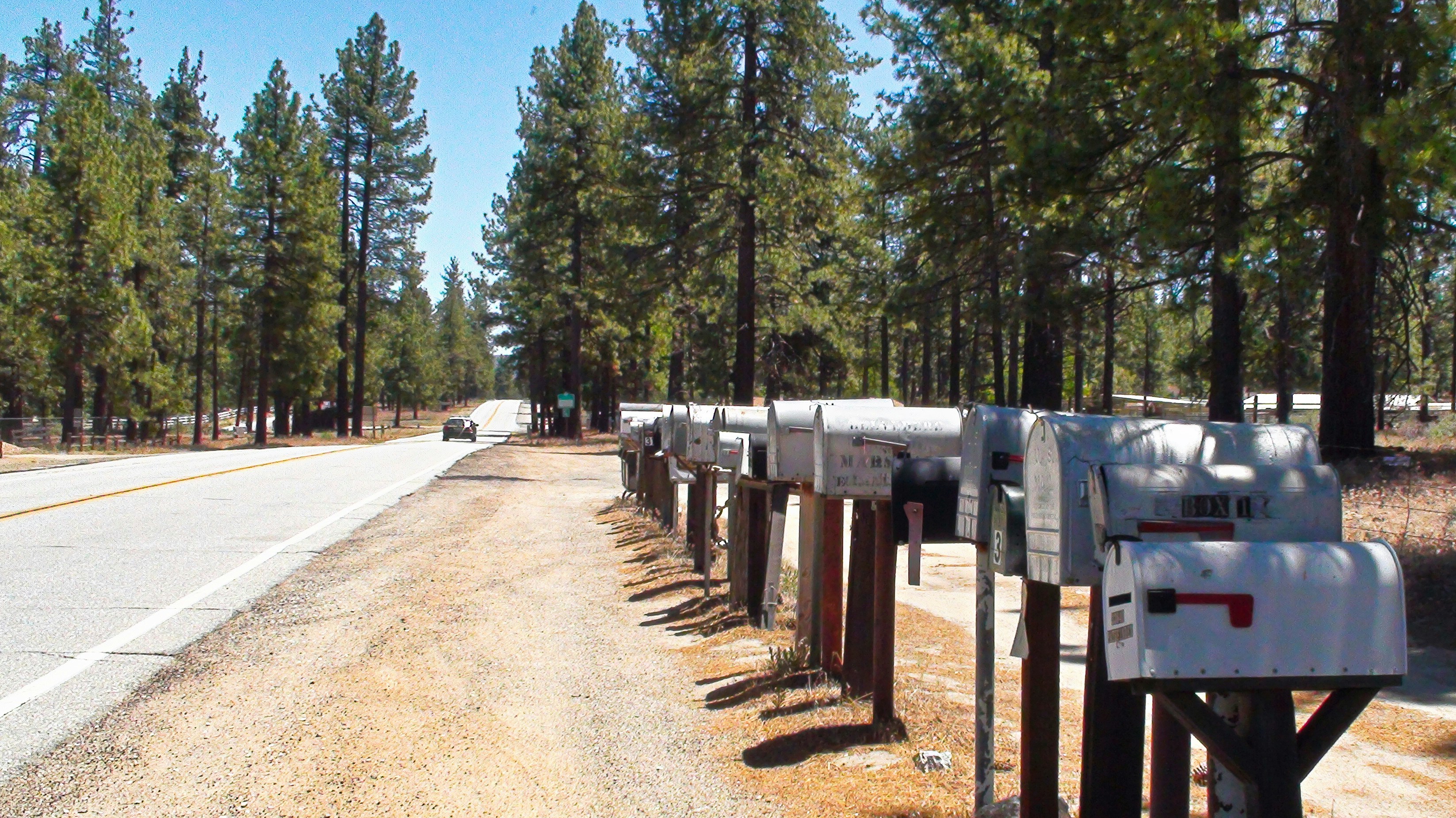 A row of mail boxes sitting on the side of a road