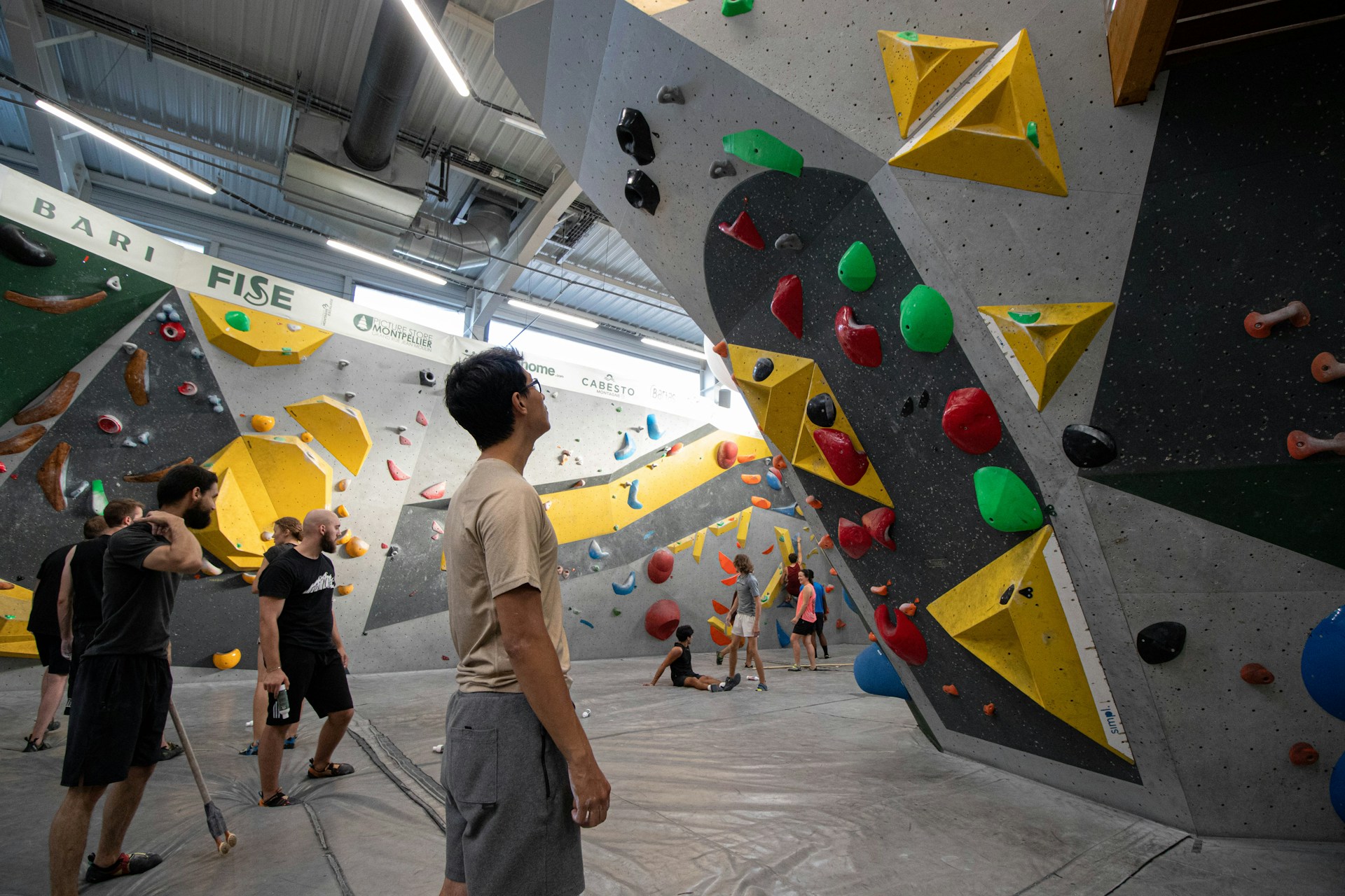 A group of people standing around a climbing wall