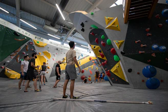 A group of people standing around a climbing wall