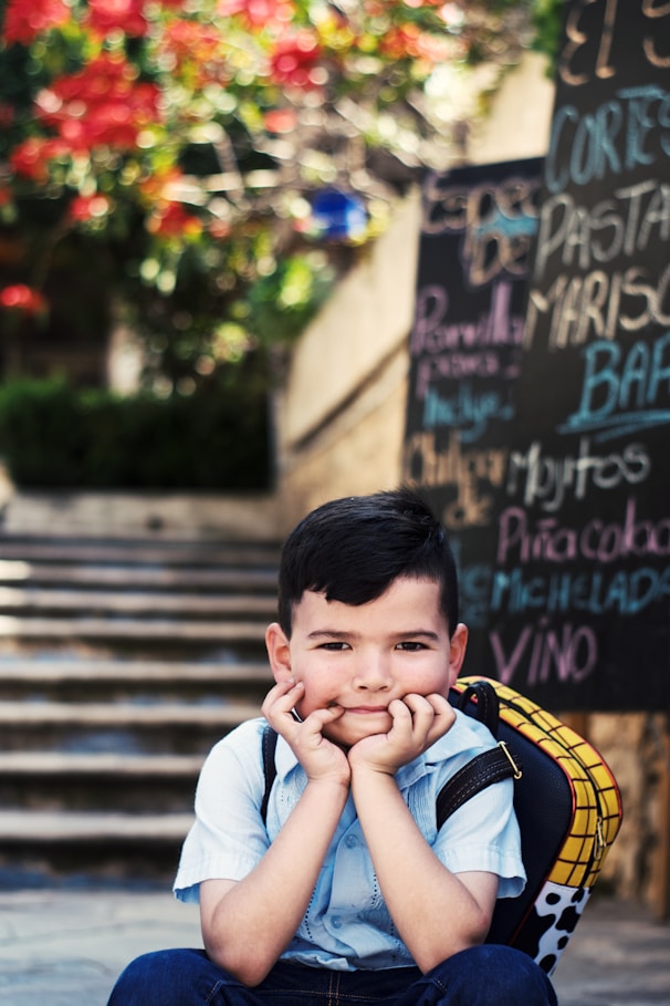 A young boy sitting on the steps of a building