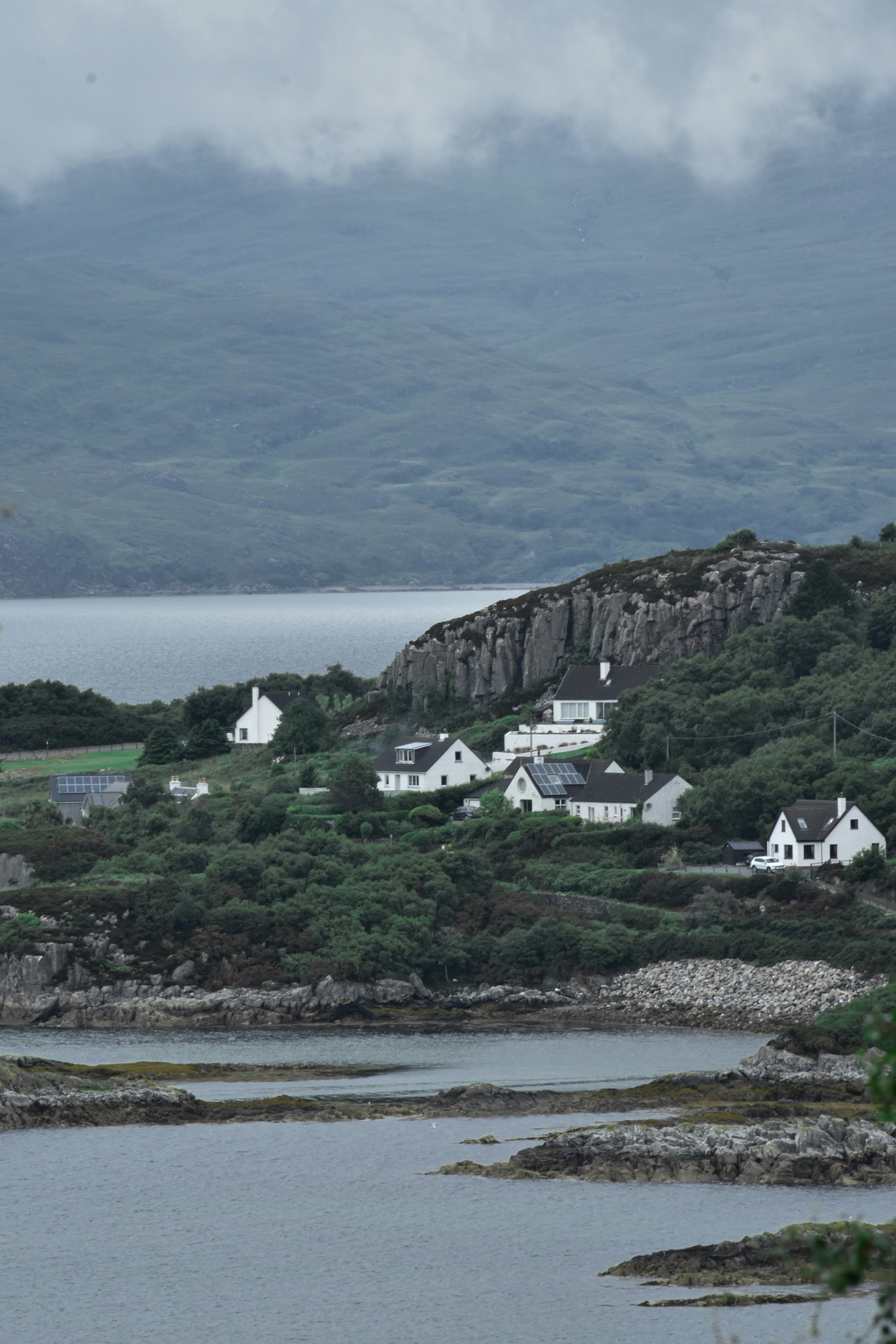 Blick auf ein kleines Dorf auf einem Hügel mit Blick auf ein Gewässer