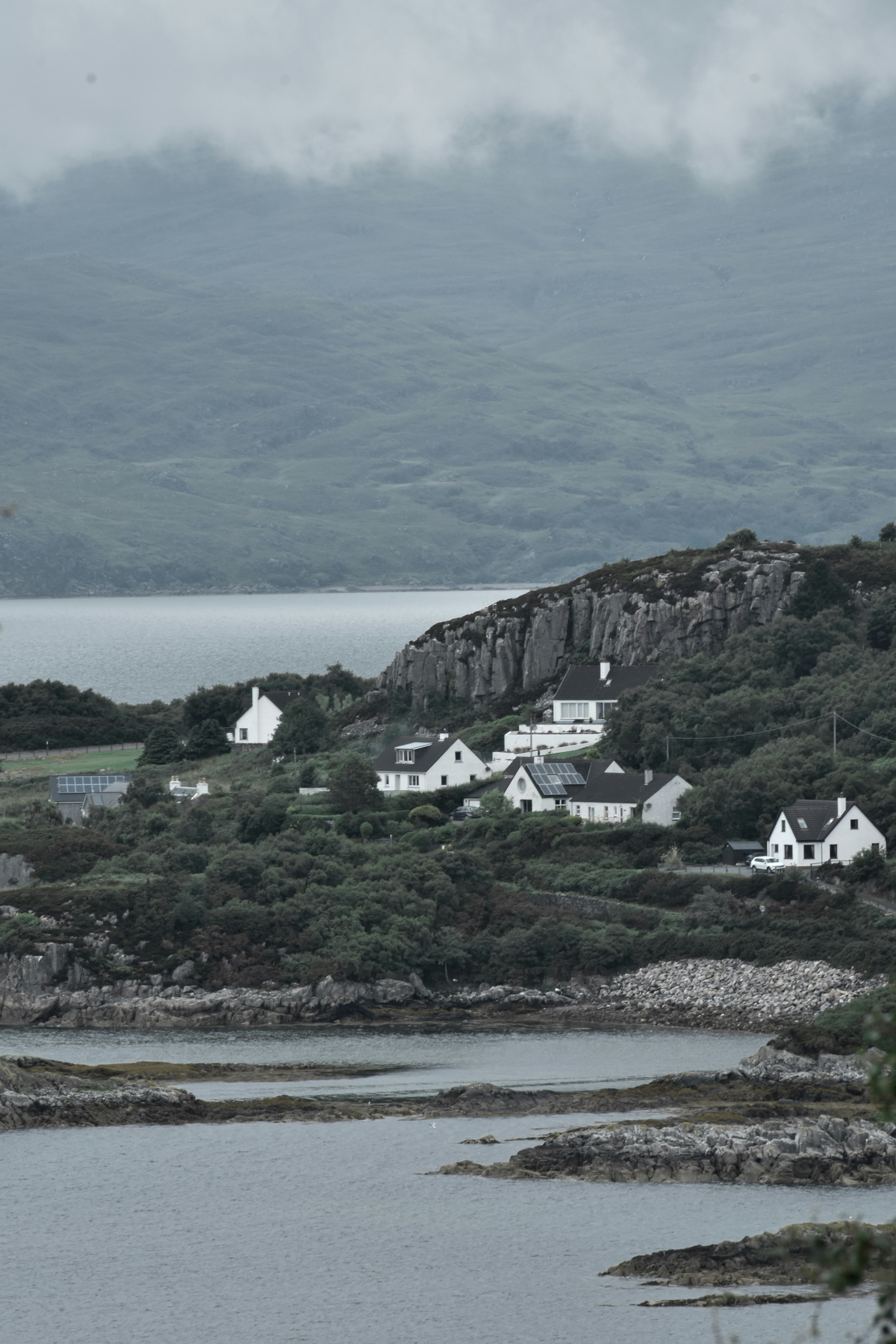 Blick auf ein kleines Dorf auf einem Hügel mit Blick auf ein Gewässer