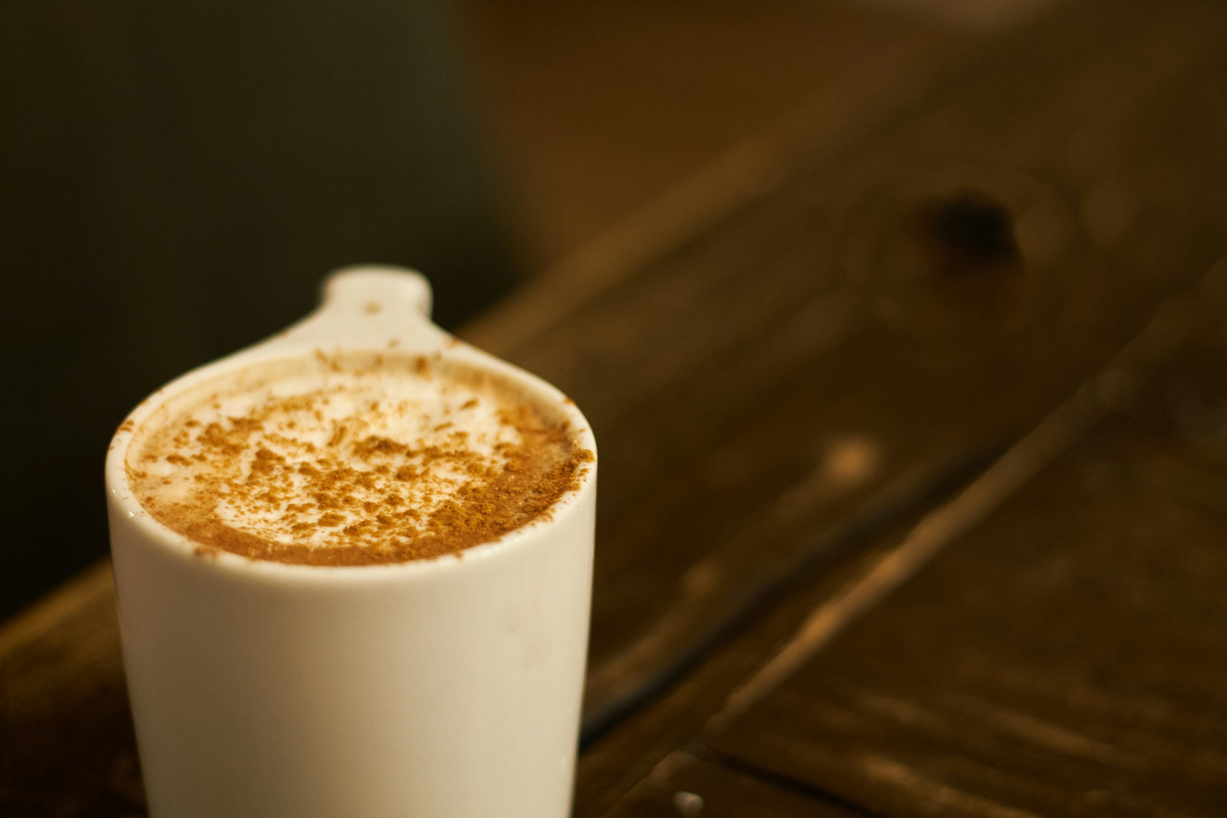 A cappuccino sitting on top of a wooden table