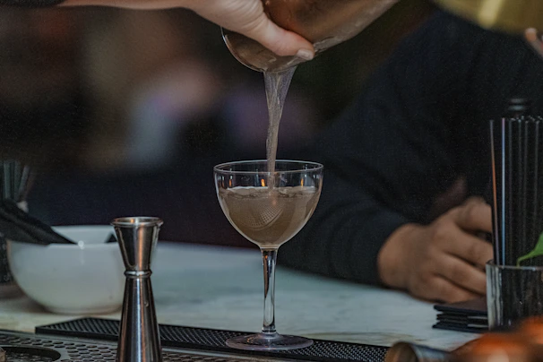 A person pouring a drink into a glass