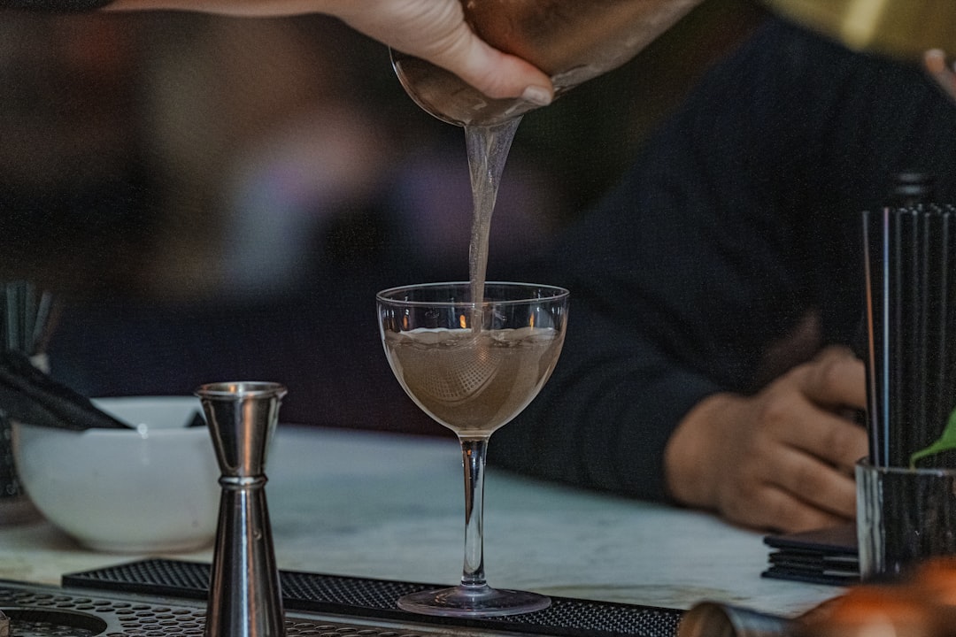 A person pouring a drink into a glass