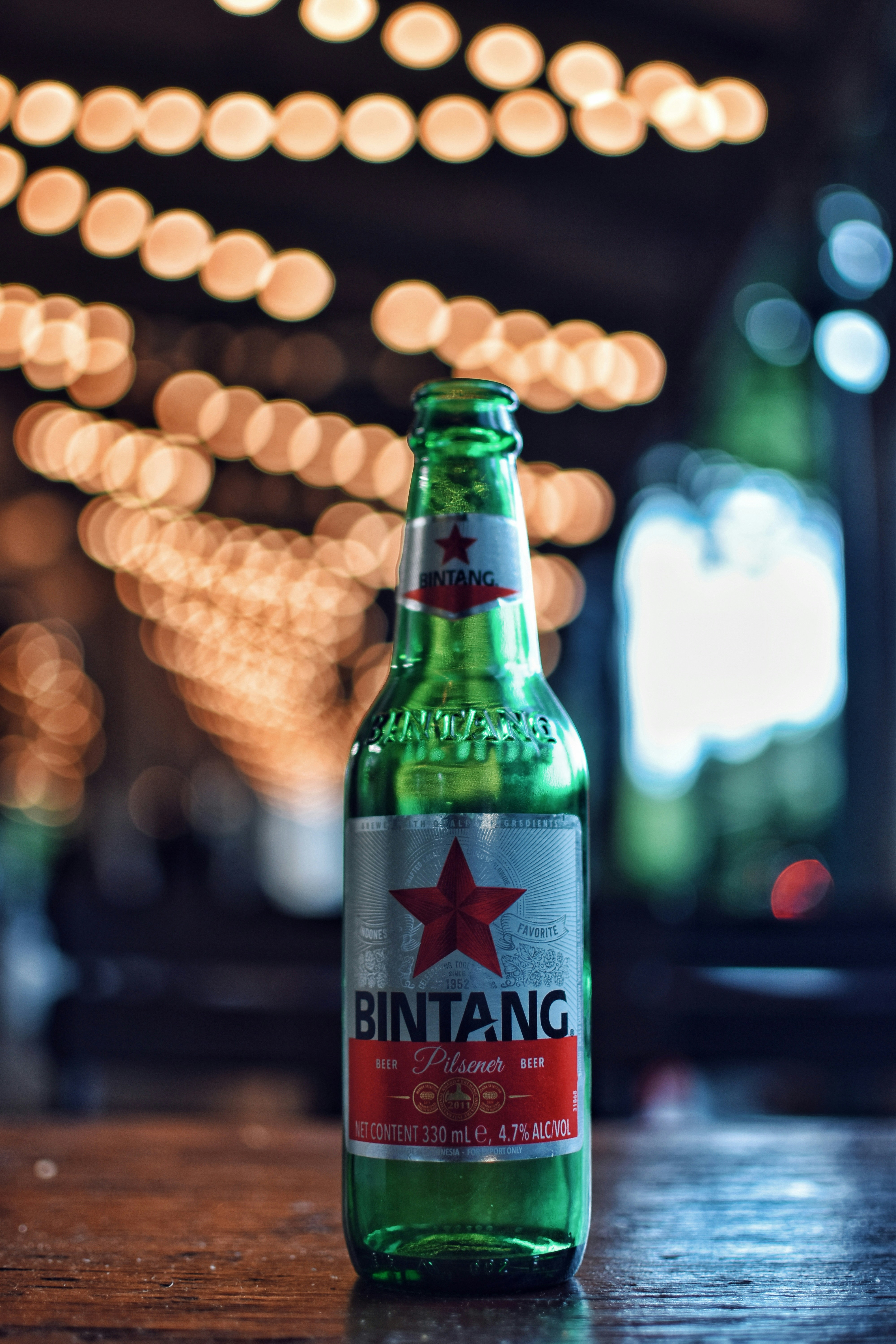 Sebotol bir duduk di atas meja kayu