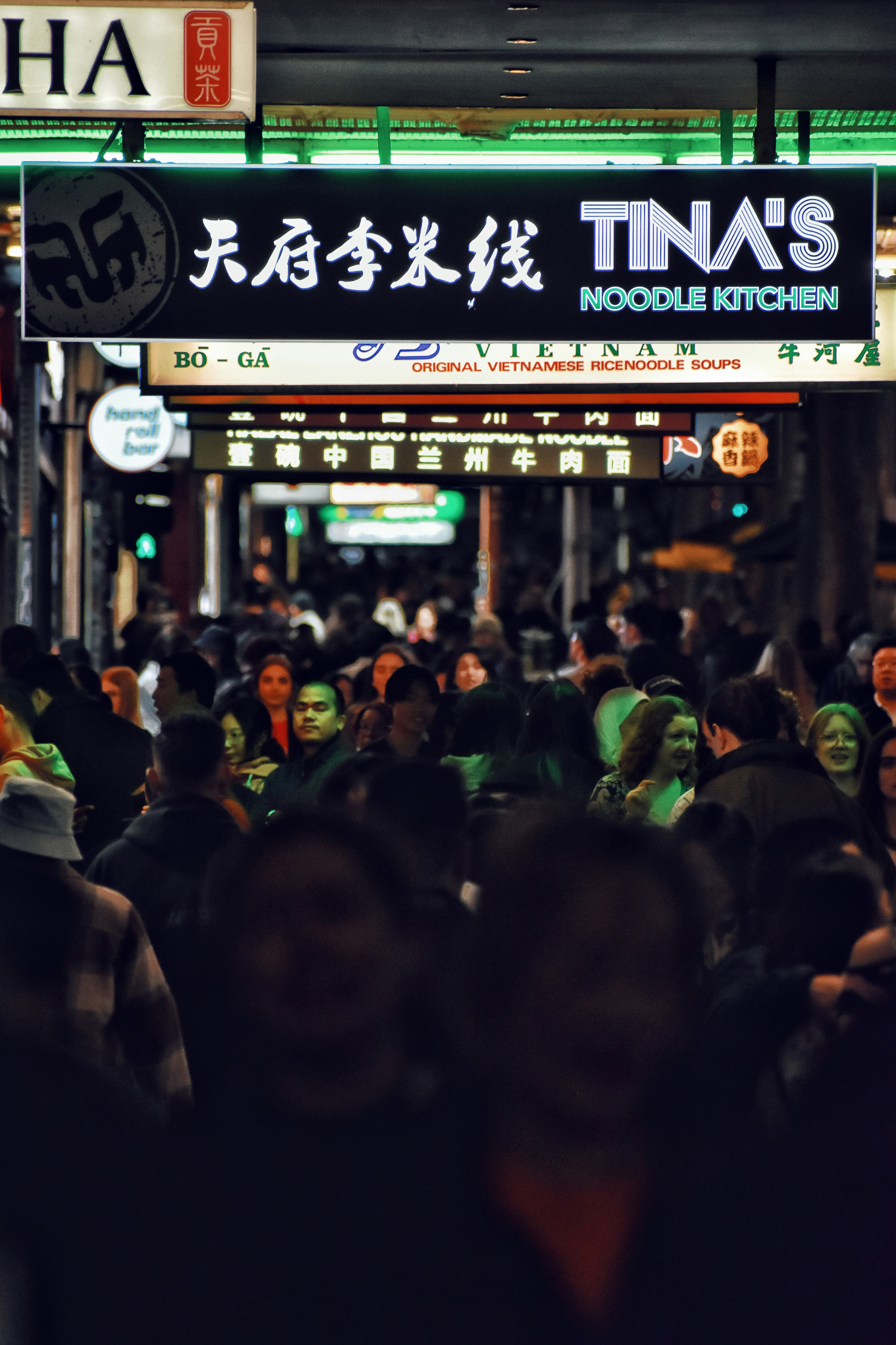 A crowd of people walking down a street at night