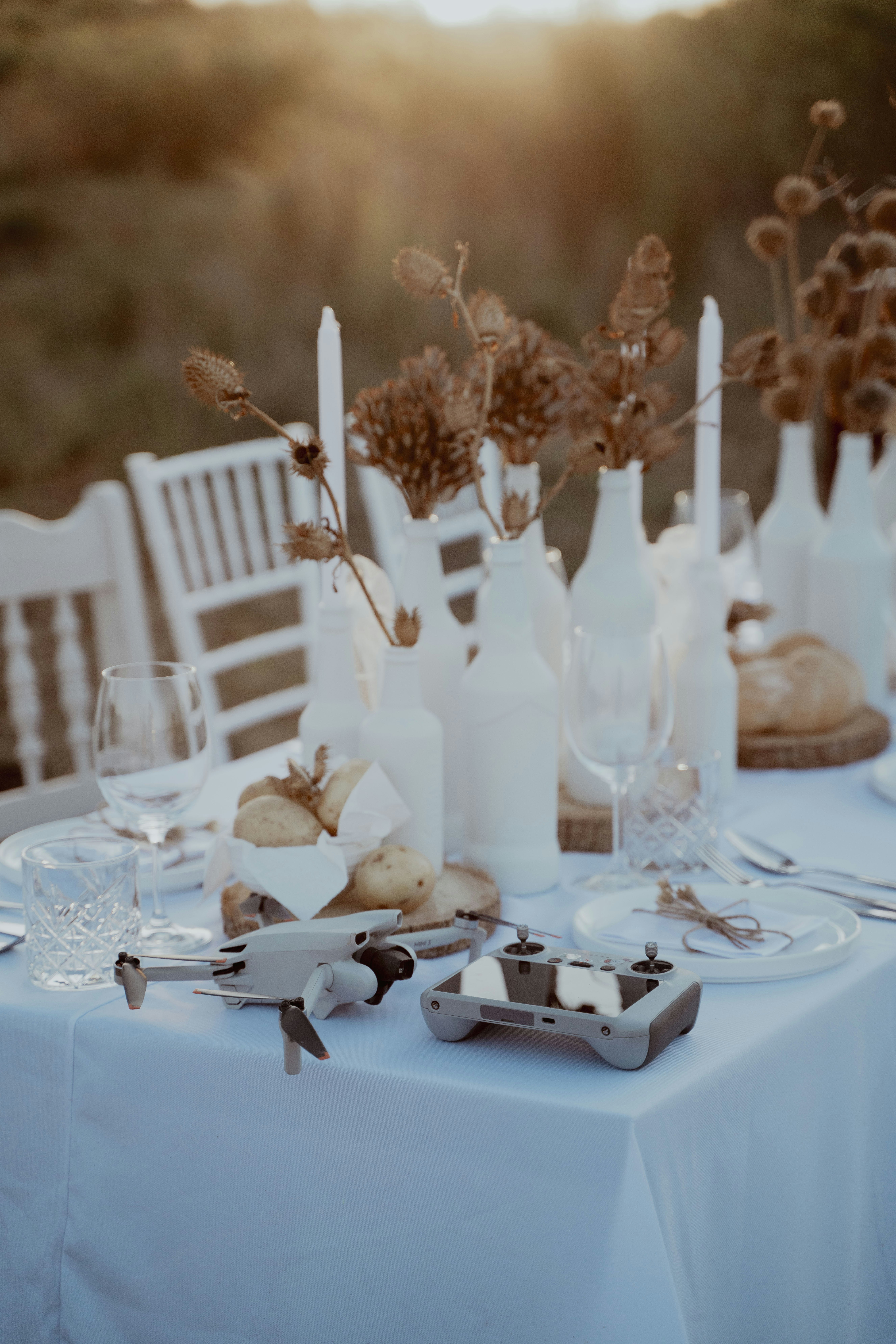 A table with a white table cloth and white chairs