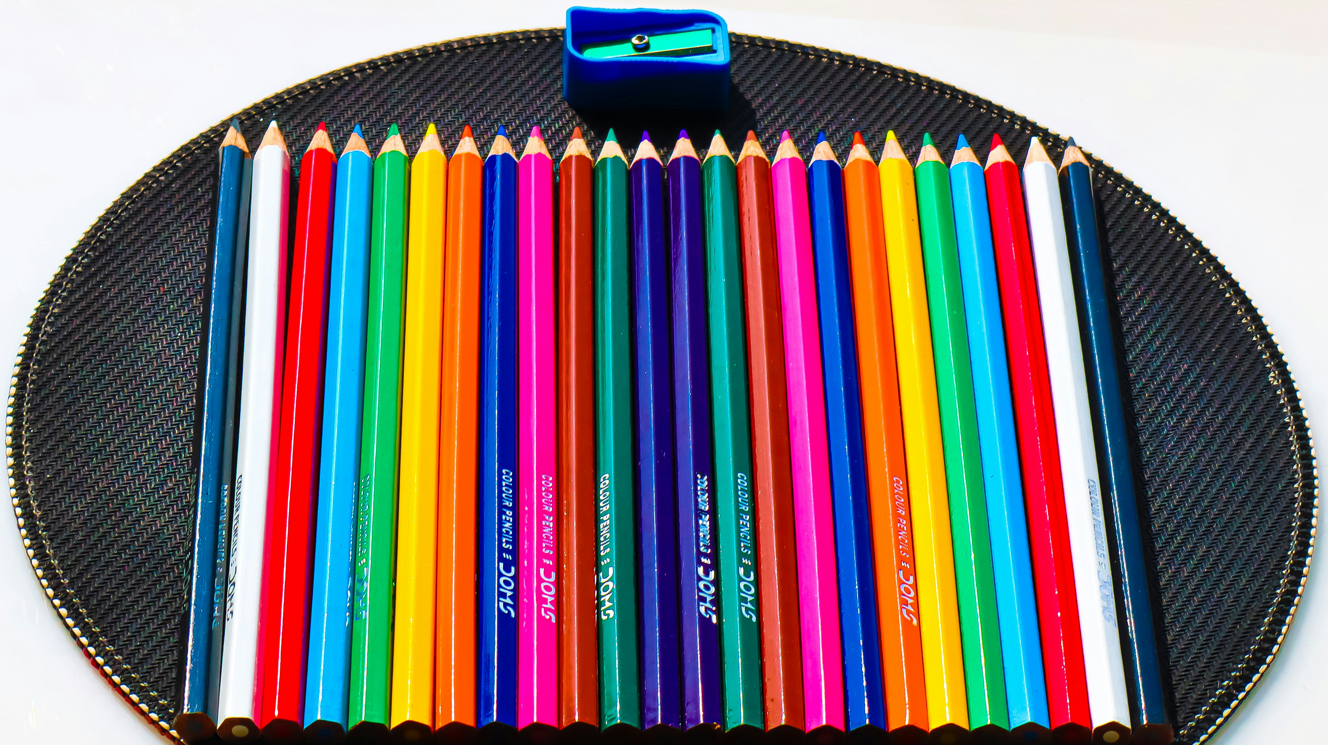 A group of colored pencils sitting on top of a black plate