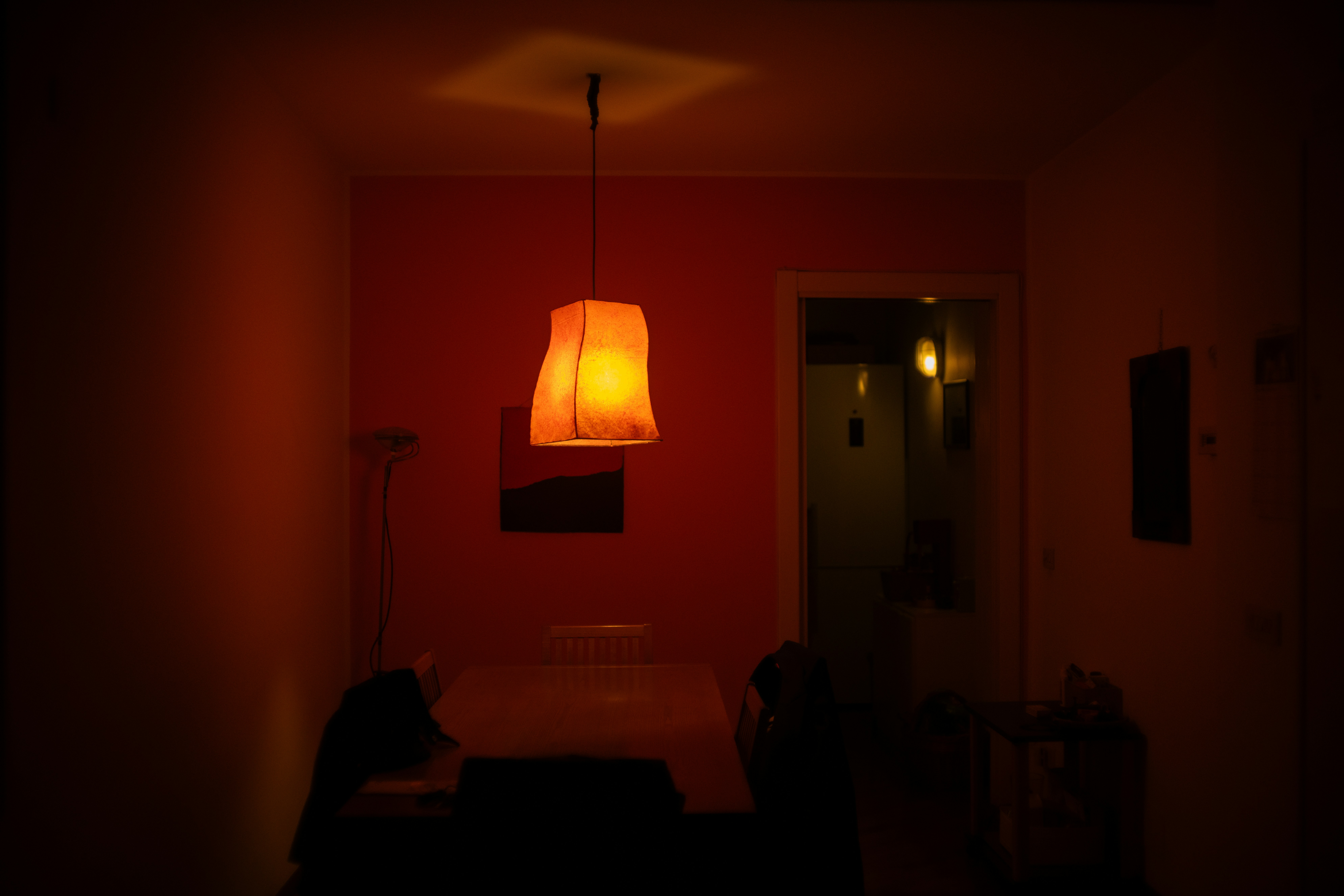 A red room with a lamp hanging from the ceiling