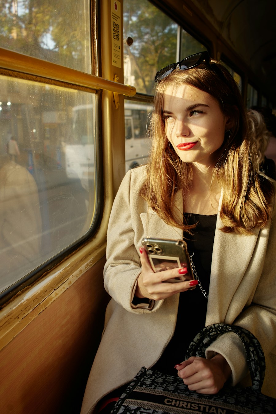 Woman on a train looking at her phone, placeholder social image