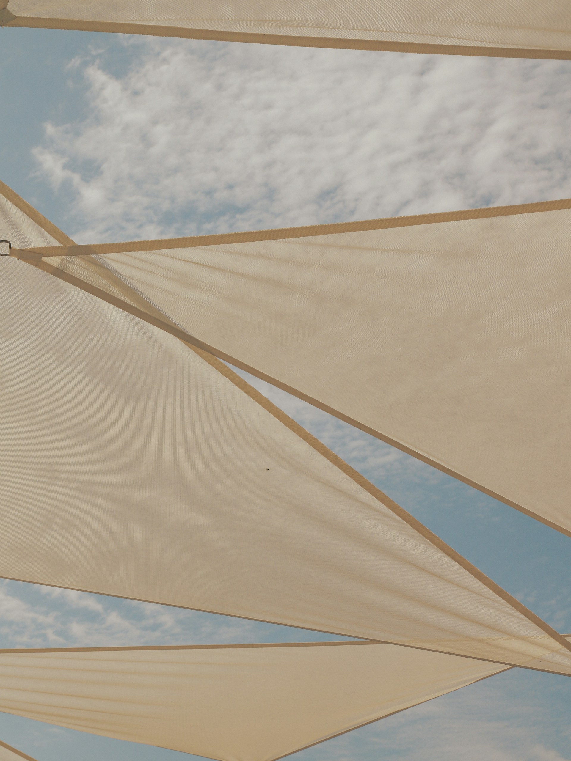 A group of white umbrellas under a cloudy blue sky