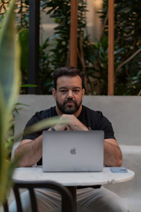 A man sitting at a table with a laptop